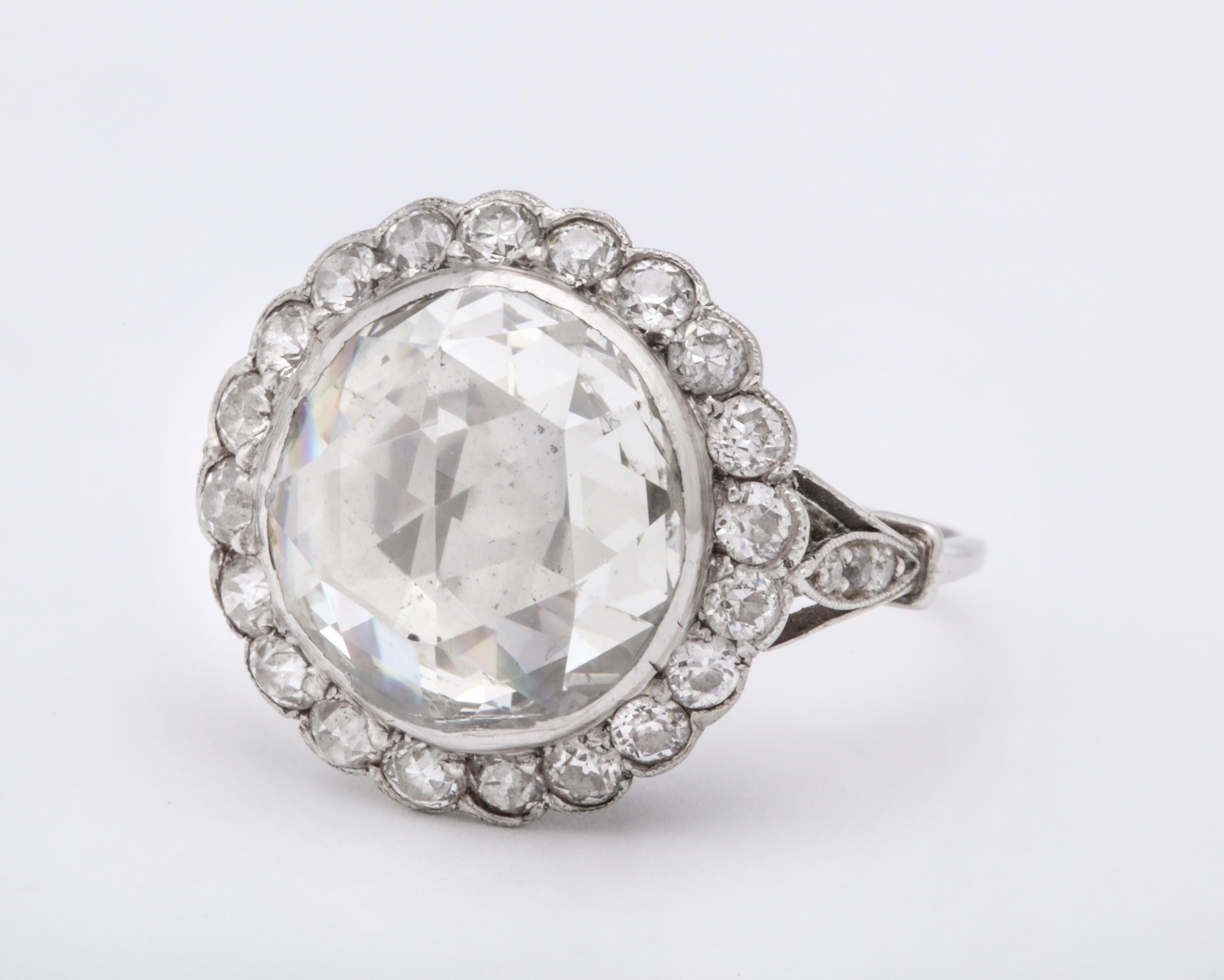 This is an exceptional Vintage rose diamond ring has a large center diamond which measures 6.5 carats but for appraisal qualification is diminished because of the flat cullet .  It is a stunning diamond  foil-backed with surrounding rose cuts in a