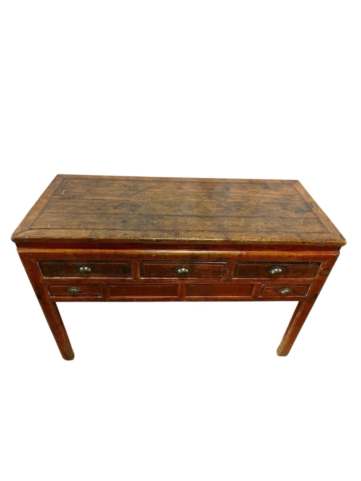 Charmante, rustique et riche en caractère, cette table console antique à 5 tiroirs de style campagne française apporte une élégance intemporelle et une fonction pratique à votre espace. Fabriquée en bois massif à la patine joliment vieillie, cette