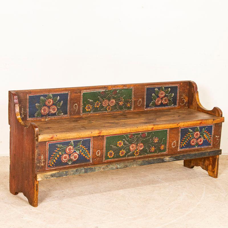This 5' pine bench still retains much of the original aged paint from 1903, when it was crafted. What makes this a special find is the unique size as most benches of this style were much longer. The traditional folk art of the late 1800's into