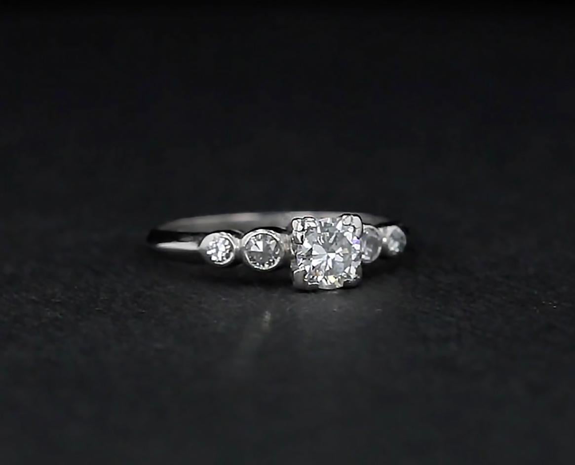 A bright white old European diamond shines from the center of this unique fine-stone platinum engagement ring. Four round diamonds bezel set on the sides offer glittering accents. 

DIAMOND DETAILS
 - Center Stone: One Old European Diamond of