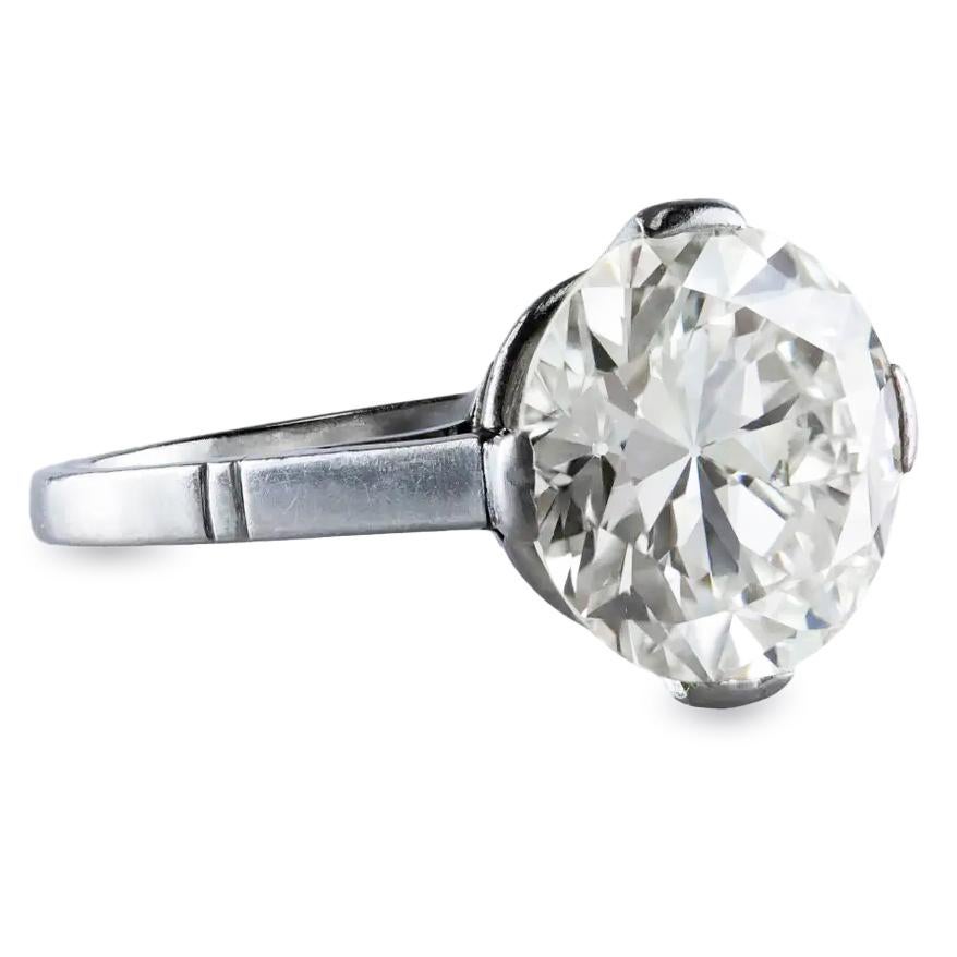 Cette magnifique bague de fiançailles ancienne met en valeur un diamant de 5,19 carats de taille Old European, certifié par le GIA comme étant de couleur N et de pureté VS1. L'anneau est élégamment placé dans une monture à pointe de compas en