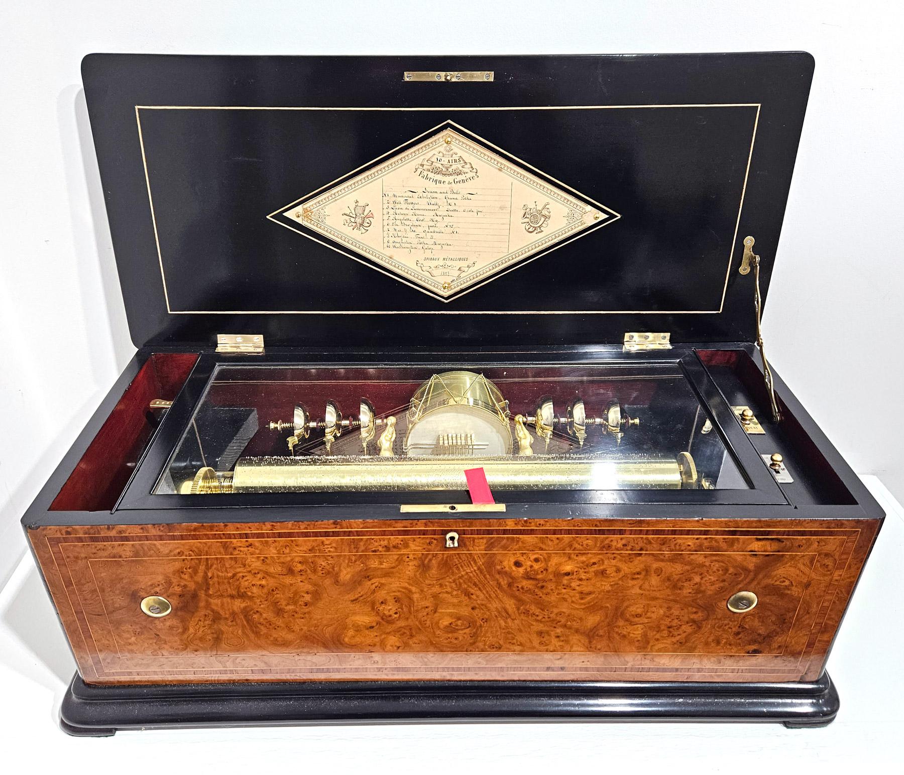 A magnificent quality six bell and drum cylinder music box made by Charles Lecoultre of Geneva, Switzerland in c. 1870.
The fully serviced musical movement features a central drum and six rack mounted saucer bells struck by axe head strikers and