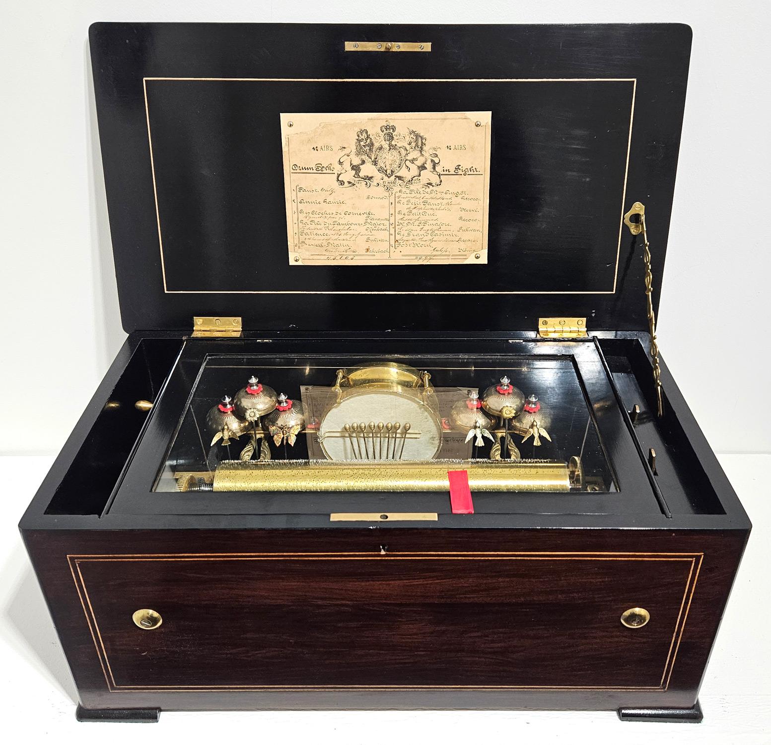 A fine quality antique music box made by George Bendon of Geneva, Switzerland in c. 1880. 

The musical movement features 6 engraved bells struck by a delightful array of figurative strikers – 4 hummingbirds, 2 flowers, and 1 butterfly. The central