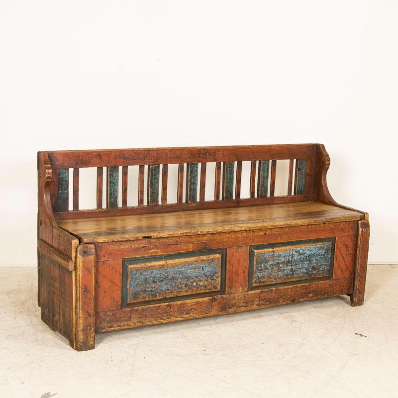 This 6' pine bench still retains much of the original aged paint from 1848 when it was crafted. What makes this a special find is the unique size as most benches of this style were longer. In addition, it was originally used as a type of spare bed,