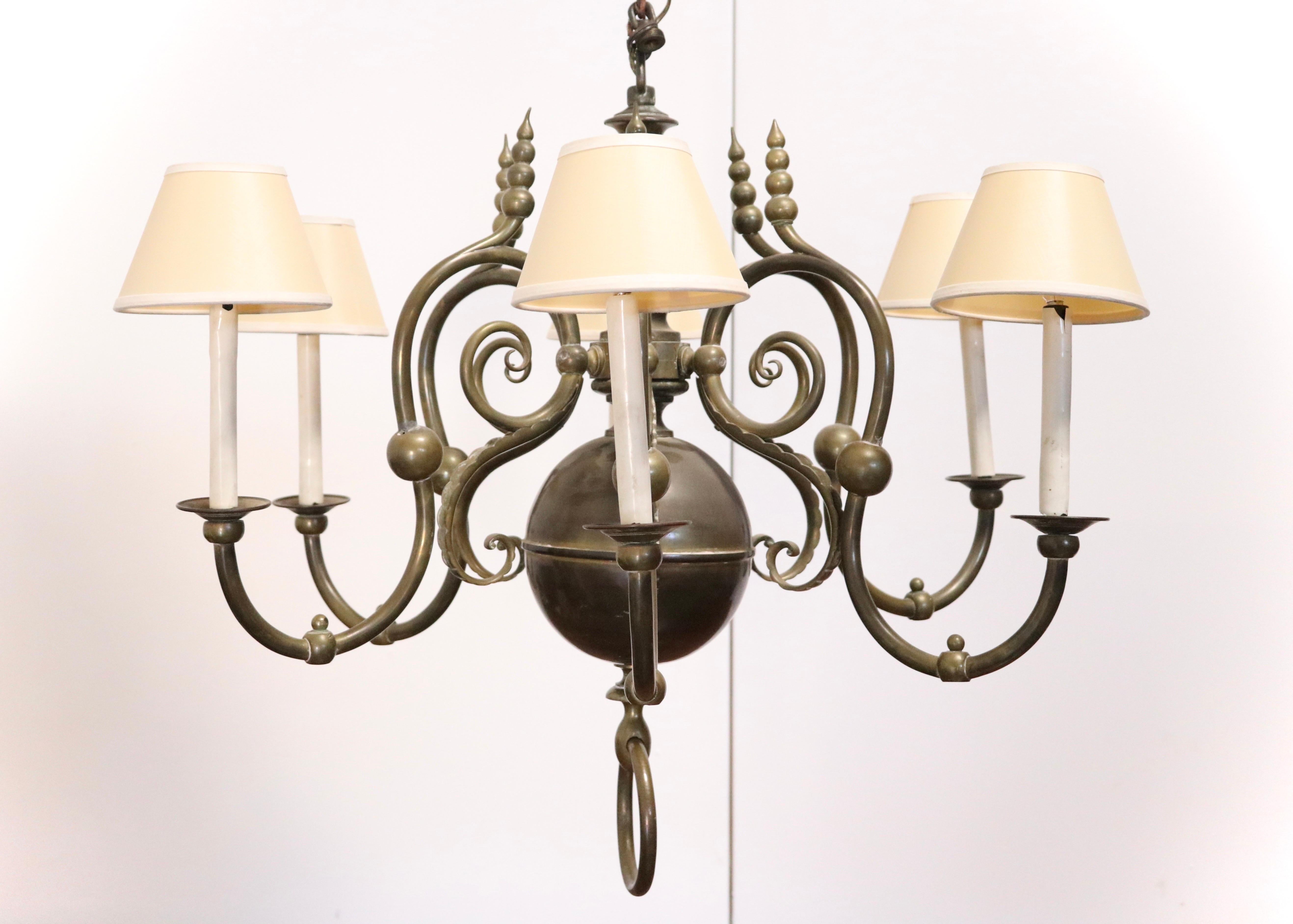 A monumental European bronze chandelier (possibly French) with 6 electrified scroll arms supporting candleholders capped with paper shades. 

Features Classic period design elements including a double globe post with each arm culminating in a thick
