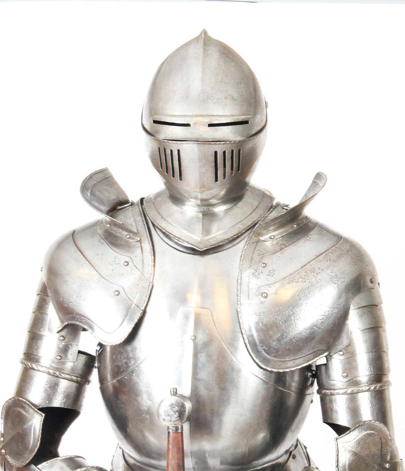 This is a fabulous antique handcrafted complete suit of life-size Greenwich style Tudor Knight plate armour dating from the early 20th century.

The finely cast fully articulated suit is mounted on a wooden Stand with an upholstered mannequin and