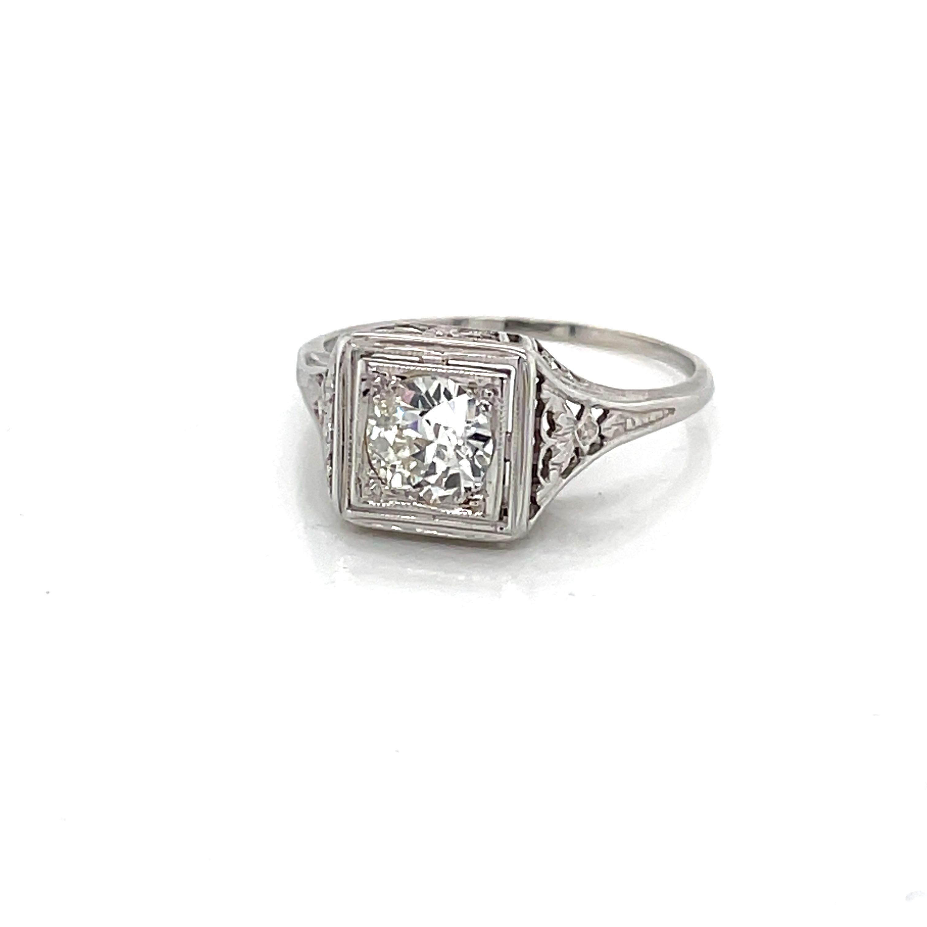 Squarely framed in a beautiful raised gallery of fine eighteen karat 18K white gold filigree is one sparkling .70 carat round H/VS Miner's cut diamond. The head of the romantic antique ring measures approximately 9x9mm and presents approximately