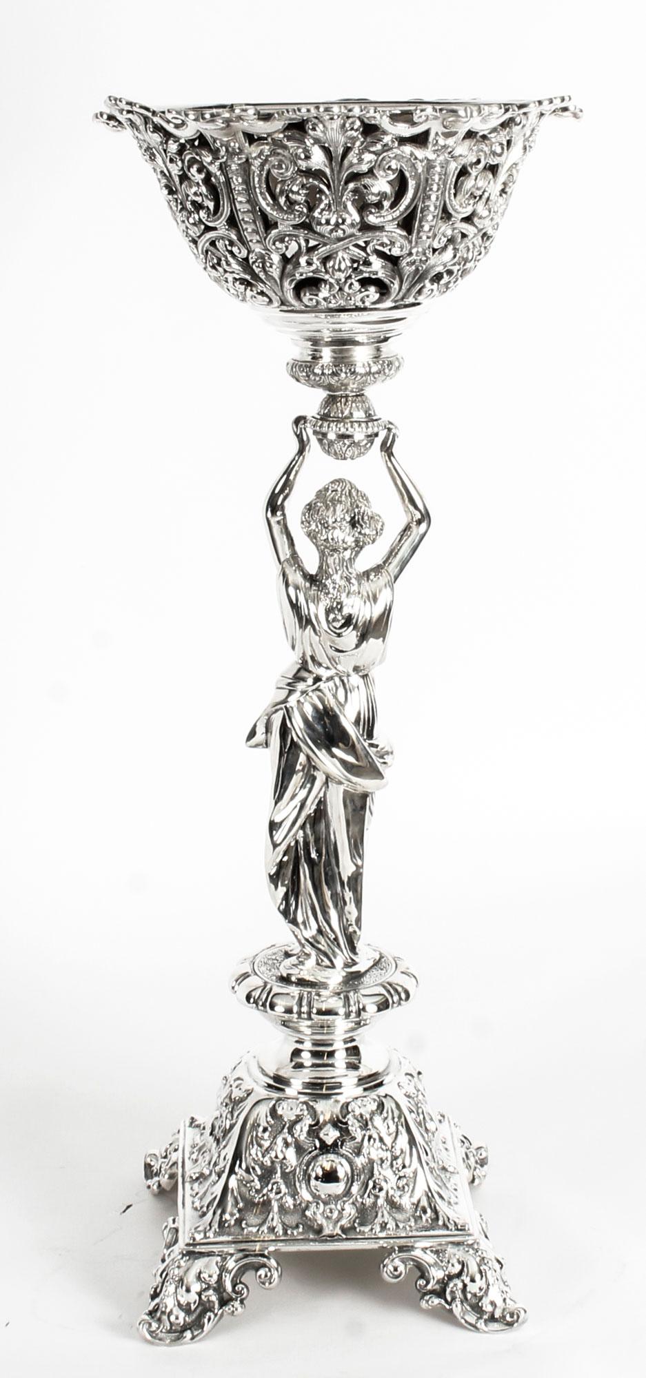 This is a wonderful and rare huge antique English Victorian silver plated bronze figural centrepiece, circa 1880 in date.

It has superb embossed and engraved decoration and features a lady in classical Greco-Roman attire holding aloft a pierced