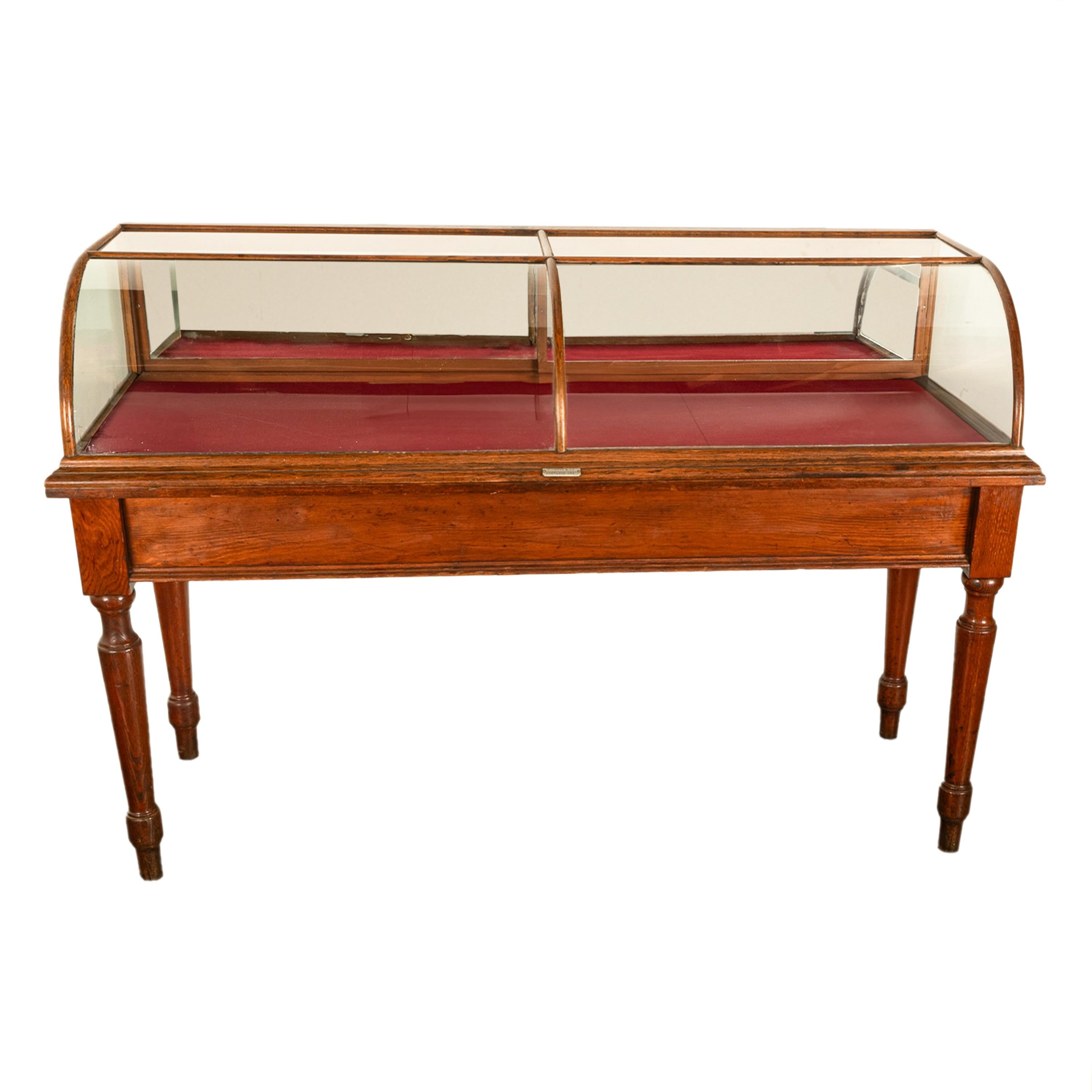 A rare antique oak and curved glass mercantile store display case and table base, R. Lutke & Co, Portland Oregon, circa 1895. (We currently have five identical cases in stock)
The case and original table base stand are in two sections, the top