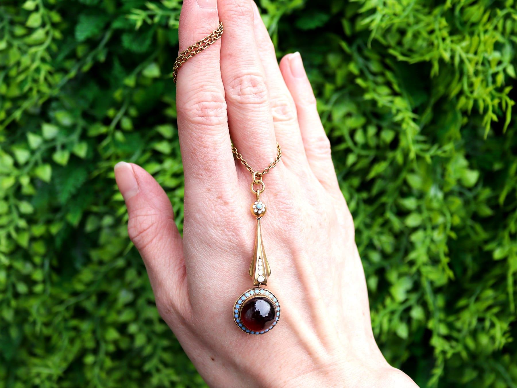 Un superbe, fin et impressionnant pendentif ancien en or jaune 18 carats de 7,90 carats avec grenat et émail et une chaîne en or jaune 21 carats ; faisant partie de nos diverses collections de bijoux anciens et de bijoux de succession.

Ce superbe