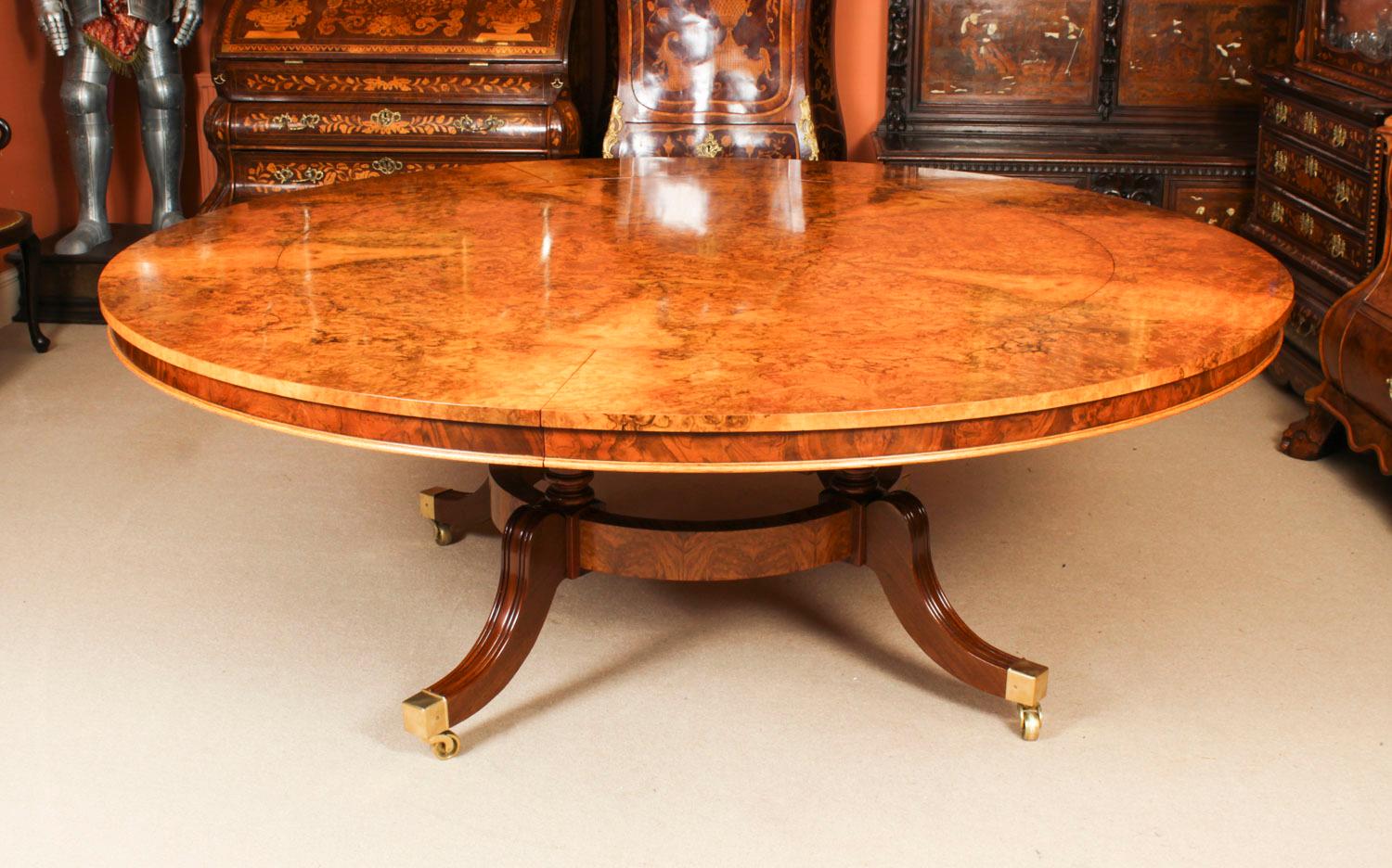This is a beautiful and rare antique Regency Revival burr walnut extending dining table  in the manner of Johnstone Jupe & Co,  Circa 1900 in date, attributed to Arthur Brett & Sons, Norfolk, England, with a set of ten vintage rope back dining