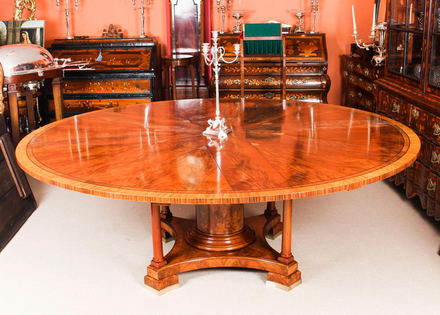 This is a beautiful flame mahogany circular expanding dining table in the manner of Johnson, Jupe & Co dating from the early 20th century.

The hexadecagon circular top features a brass capstan action rotating eight triangular segments to