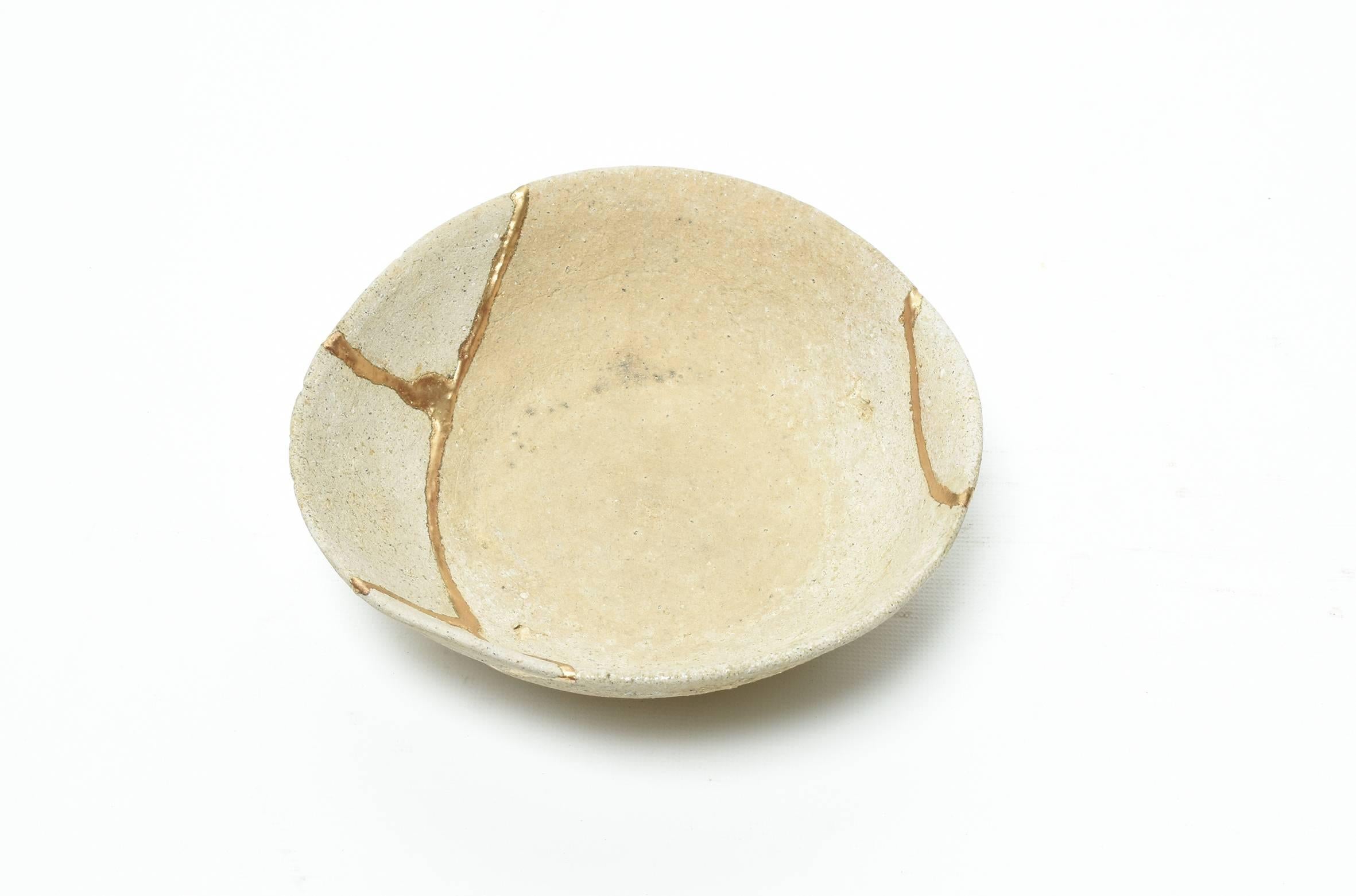 Antique Japanese pottery bowl with Kintsugi gold lacquer repairs running over its unglazed bare clay body, from Nara period, 7th century. The bowl has a rough textured threaded with genuine gold repaired seams.

Please note: All ceramic items