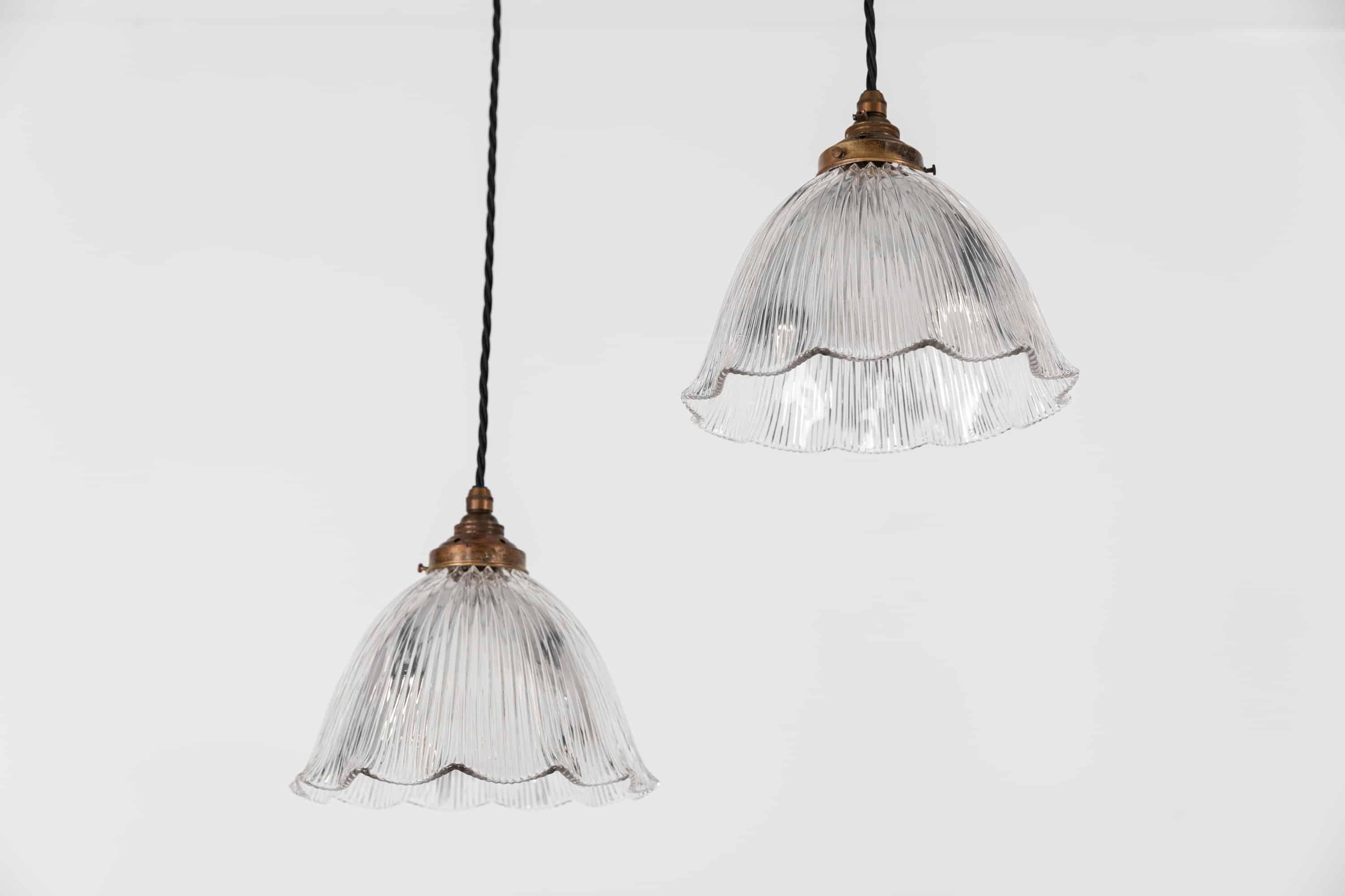 Elegantly formed prismatic glass 'Stiletto' pendant lights made in England by Holophane, circa 1920.

Clear scalloped designed glass with Holophane stamp to the rim of the shade. Period brass galleries. Price is per lamp.

Rewired with 1m of
