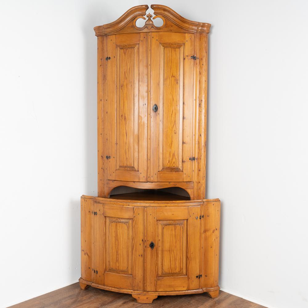 This stunning Swedish country corner cupboard reveals its age in the deep, warm patina of the aged pine.
Standing at 8' tall and crowned with a lovely carved bonnet, this stately corner cabinet will make a strong statement in any room.
Upper