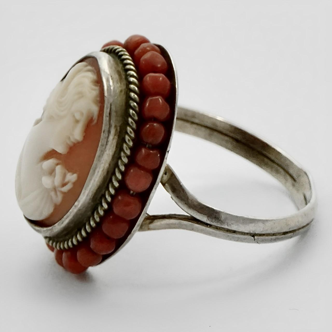 Beautiful 800 silver and shell cameo ring, with rope twist detail and a coral bead surround. Ring size UK N 1/2, US 6 3/4, and measuring diameter approximately 1.8 cm / .7 inch. There is scratching as expected. The ring was originally gold plated,
