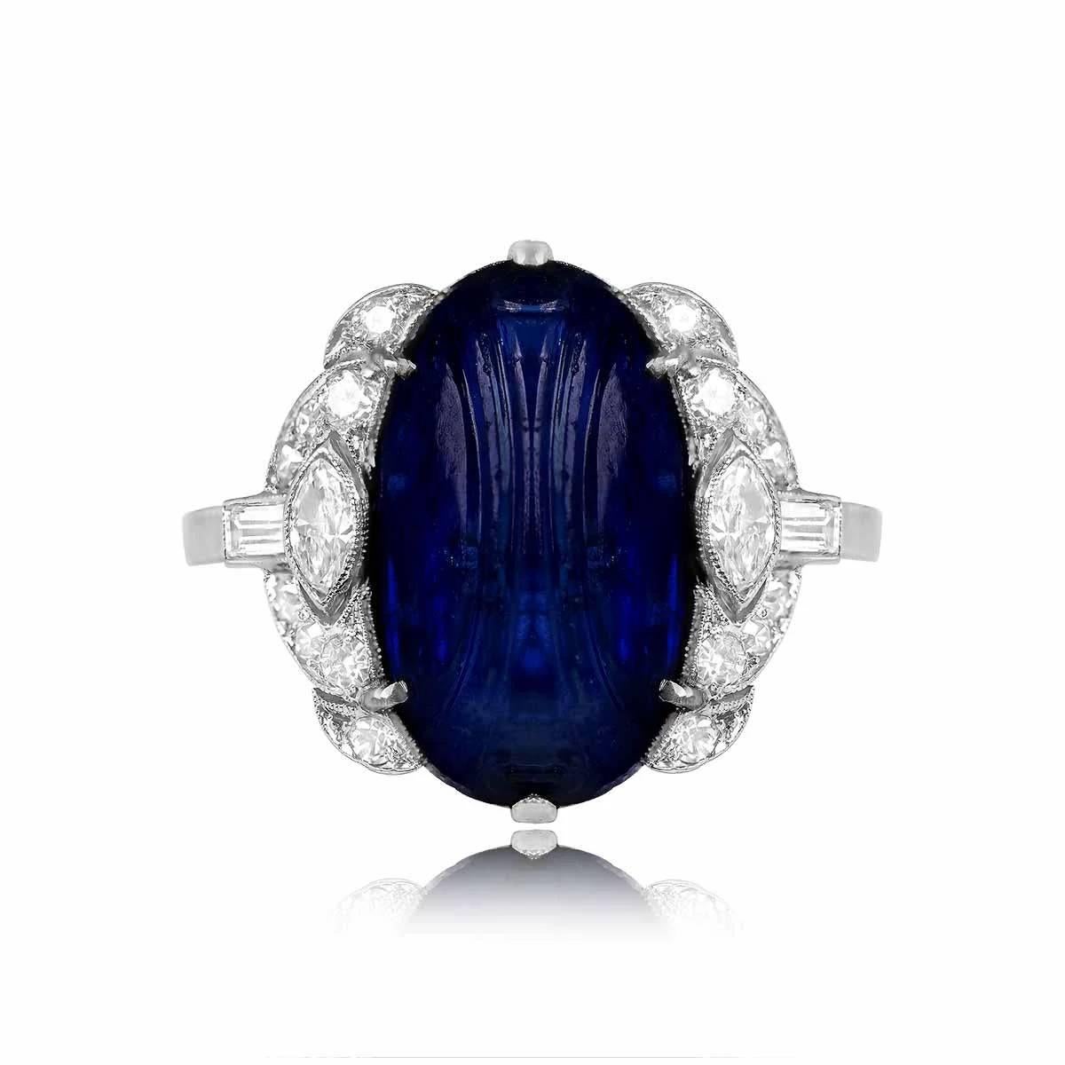 This exquisite Art Deco ring showcases an 8.64-carat natural Burmese-carved cabochon sapphire as its centerpiece. Surrounding the sapphire are dazzling single-cut, marquise, and baguette-cut diamonds. Crafted in the 1920s, this antique ring is a