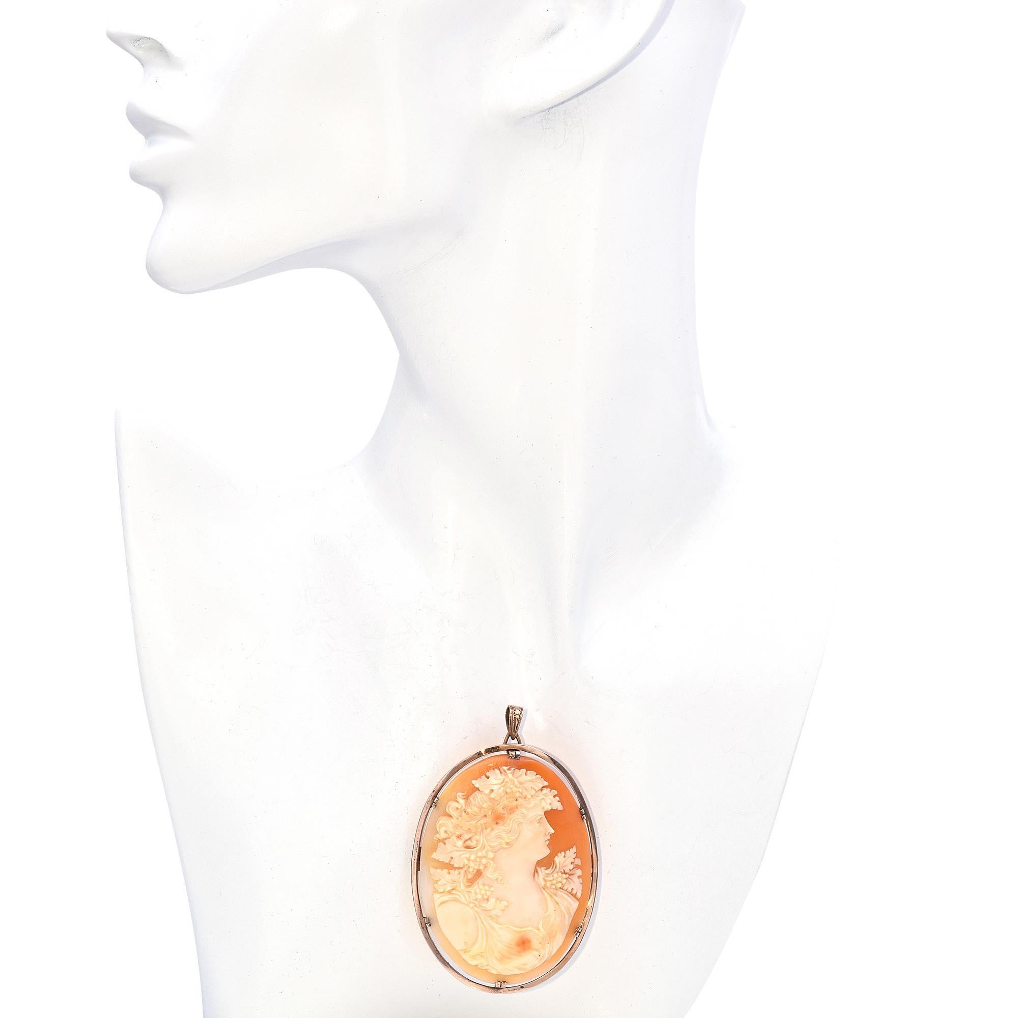 This exquisite antique 8K rose gold cameo pendant brooch showcases a finely hand-carved shell cameo depicting a classical female figure adorned with grapevines, symbolizing Bacchante, the followers of Bacchus, the god of wine and revelry. The