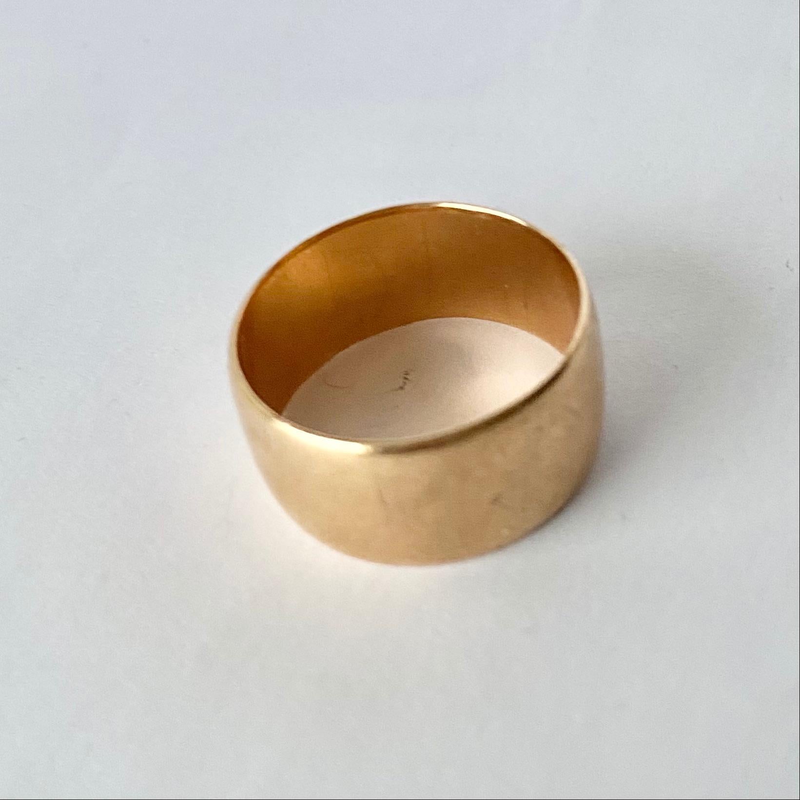 This band is plain and modelled in glossy 9ct gold. It could be worn as an every day ring or a classic wedding ring. 

Ring Size: S or 9 1/4  
Band Width: 10mm 

Weight: 6.8g