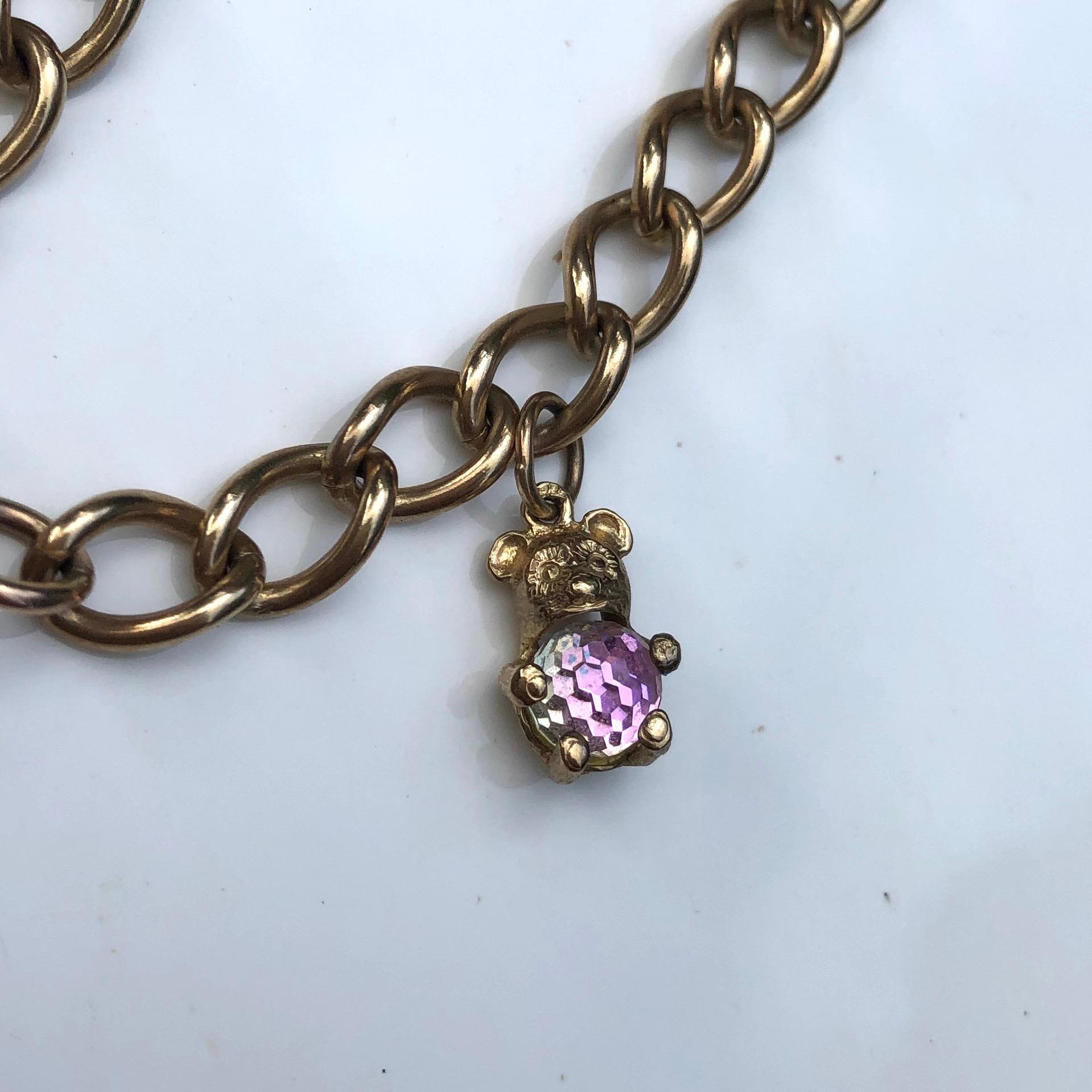 This classic curb bracelet has smooth links and to fasten this bracelet there is a heart locket which is smooth and glossy with safety chain. Attached to the chain is the sweetest teddy charm with a crystal tummy! Modelled in 9ct gold and made in