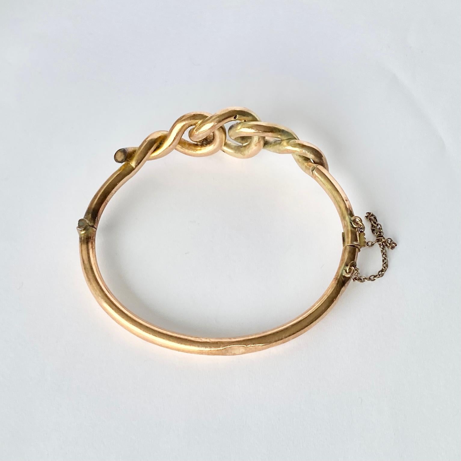 This gorgeous 9carat gold bangle has the intertwining lovers knot as the main detail. The gold is glossy and smooth and the fastening has a safety chain. 

Inner diameter: 58mm 
Width: 18mm

Weight: 10g