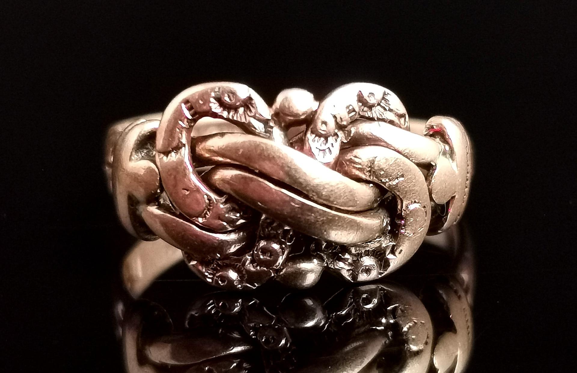 A gorgeous antique 9kt Rose gold lovers knot ring.

It has a decorative engraved 'lovers knot' design face in rich old 9kt Rose gold.

It has smooth tapered shoulders and a plain band.

Fully hallmarked for 9ct gold Chester 1915.

The lovers knot