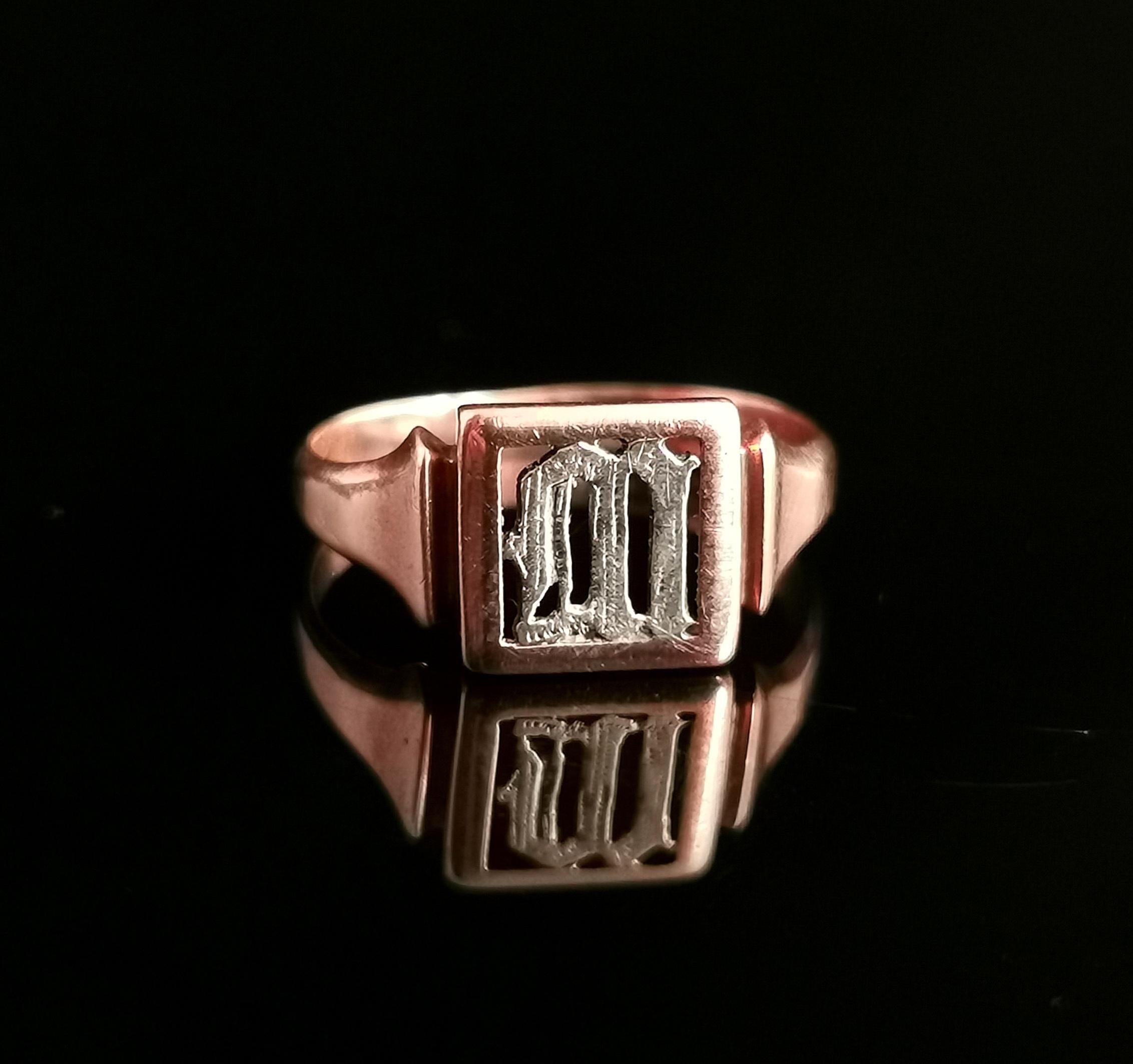 An attractive and interesting antique signet ring.

Early 20th century, it is crafted from 9 karat Rose gold and has an intricate cut out design with the letter M in gothic script.

The M is crafted from sterling silver and this gives a beautiful
