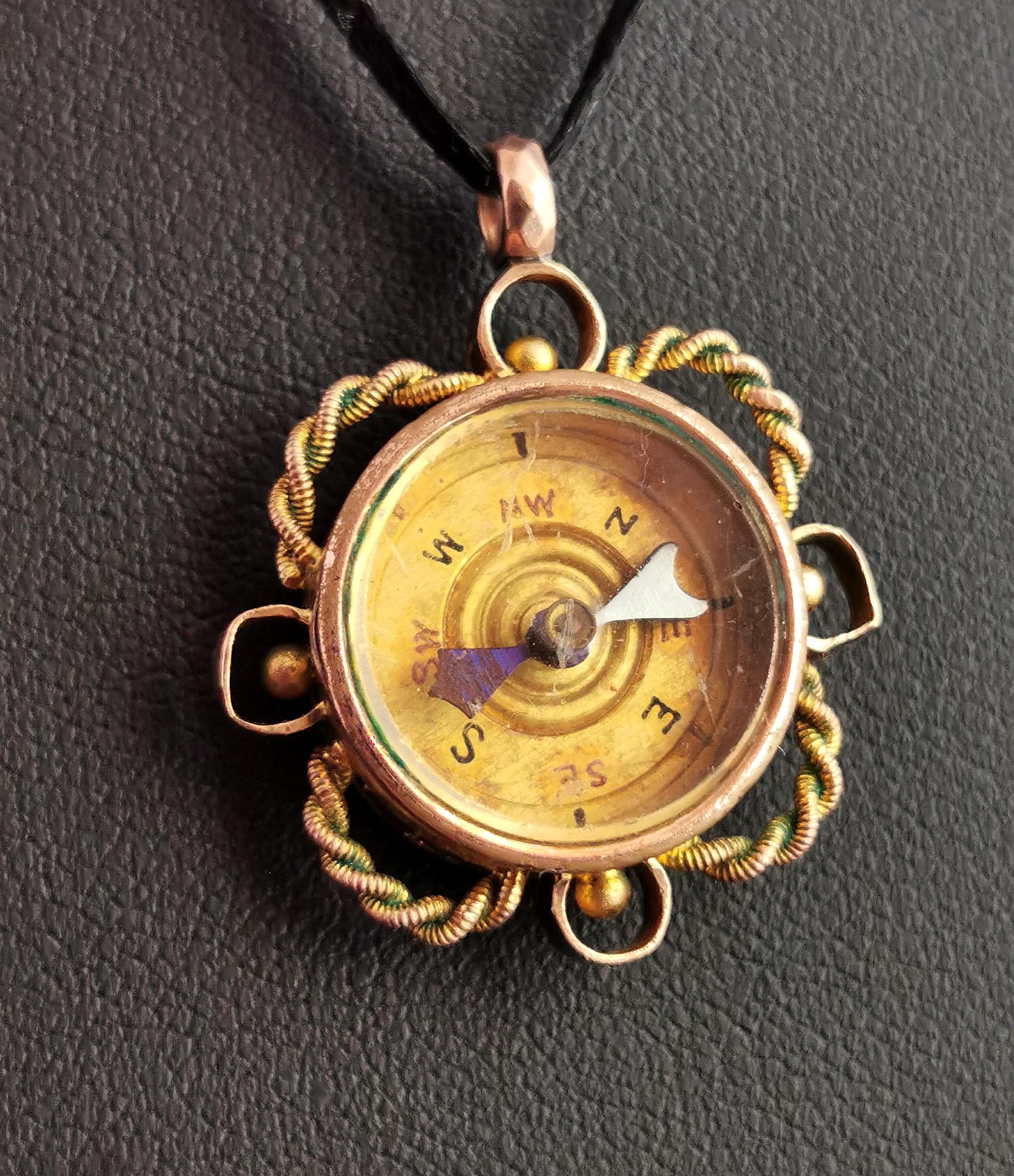 A sweet antique 9 karat yellow gold compass pendant set with a Carnelian fob.

This lovely little gilded working compass is set into a fancy 9 karat gold frame with twisted wirework and loop detailing.

The reverse is set with a smooth rich red