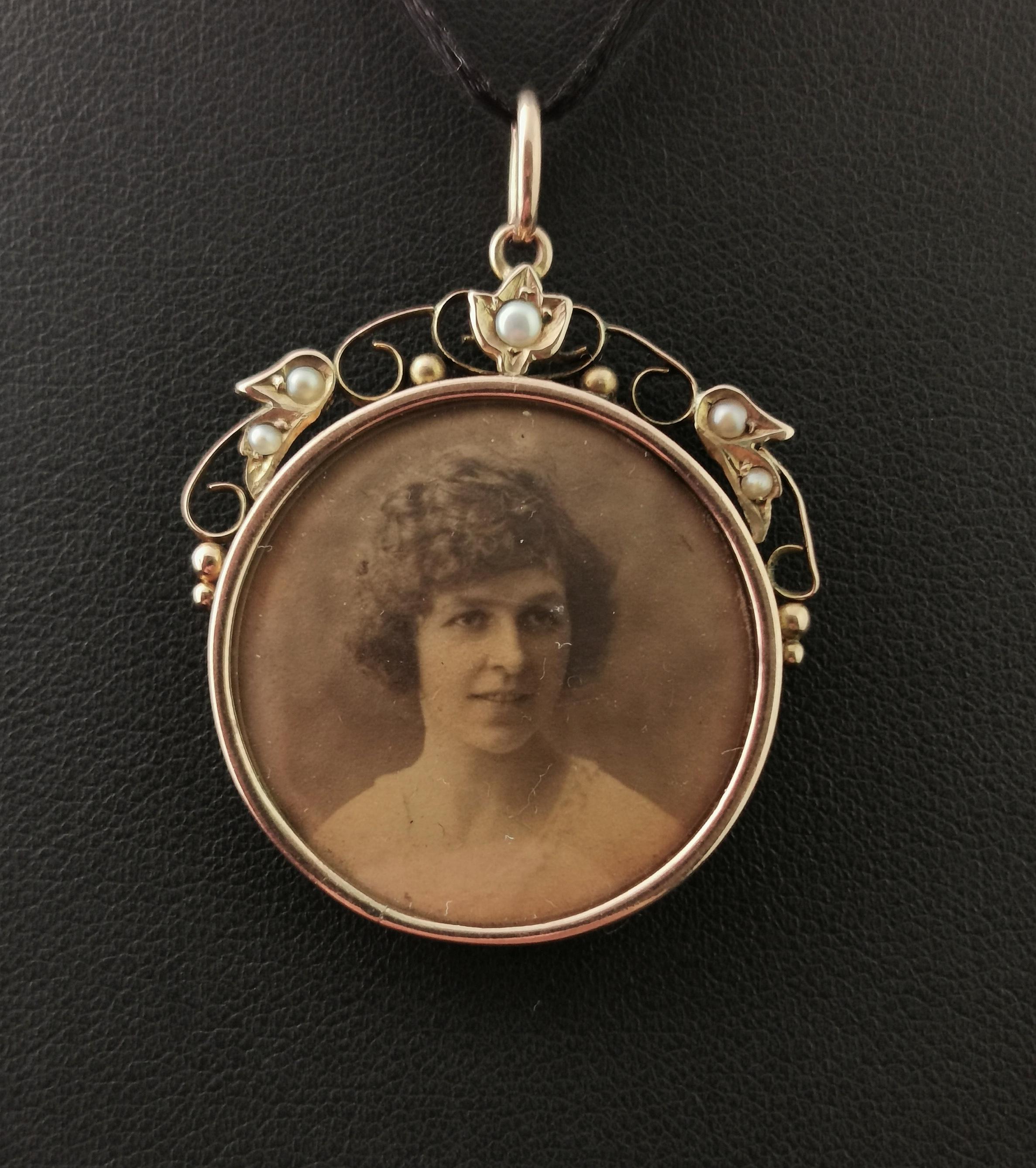 A gorgeous antique 9 karat gold portrait pendant or locket.

It has a 9 karat yellow gold frame with a pretty stylised top with scrolling gold work and leaves and flower, set with tiny creamy seed pearls.

There are two clear glass panels, it