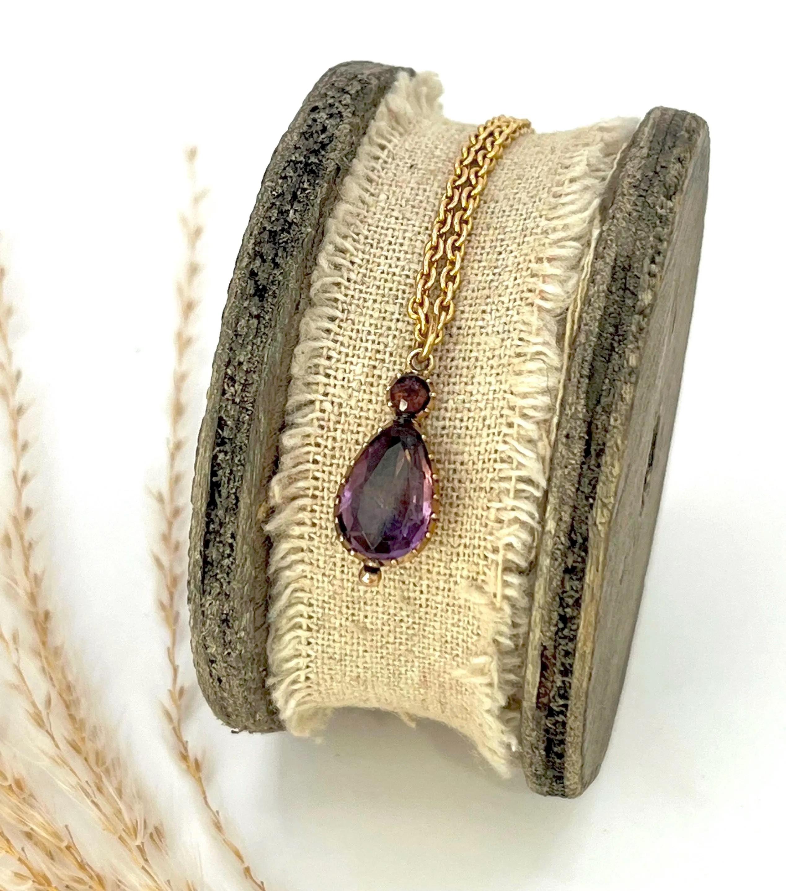 Antico ciondolo georgiano in ametista 

Oro 9ct

Circa 1850 

*La catena è venduta separatamente. 

Realizzato in oro, questo ciondolo presenta un'ametista a goccia sospesa sotto un'ametista rotonda più piccola, entrambe incastonate in montature