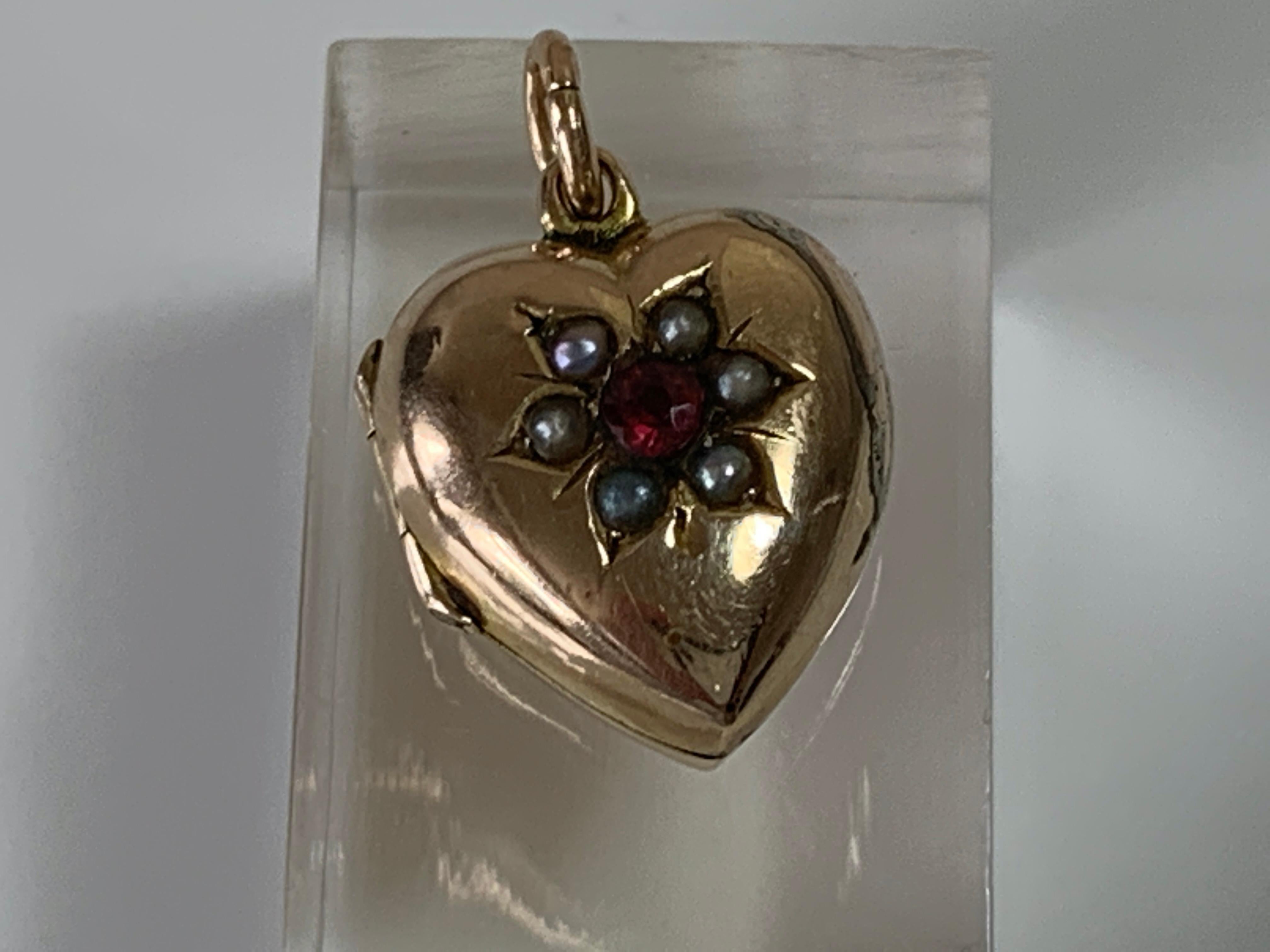 Antique 9ct gold Locket
-snaps shuts securely
Light Blue whole Oil Pearls surround a central bright red gem
Fully Hallmarked on reverse 
Chester Hallmarks -makers AW Date letter P 1898
and on the Ring 9 375
Sold as seen in Images
