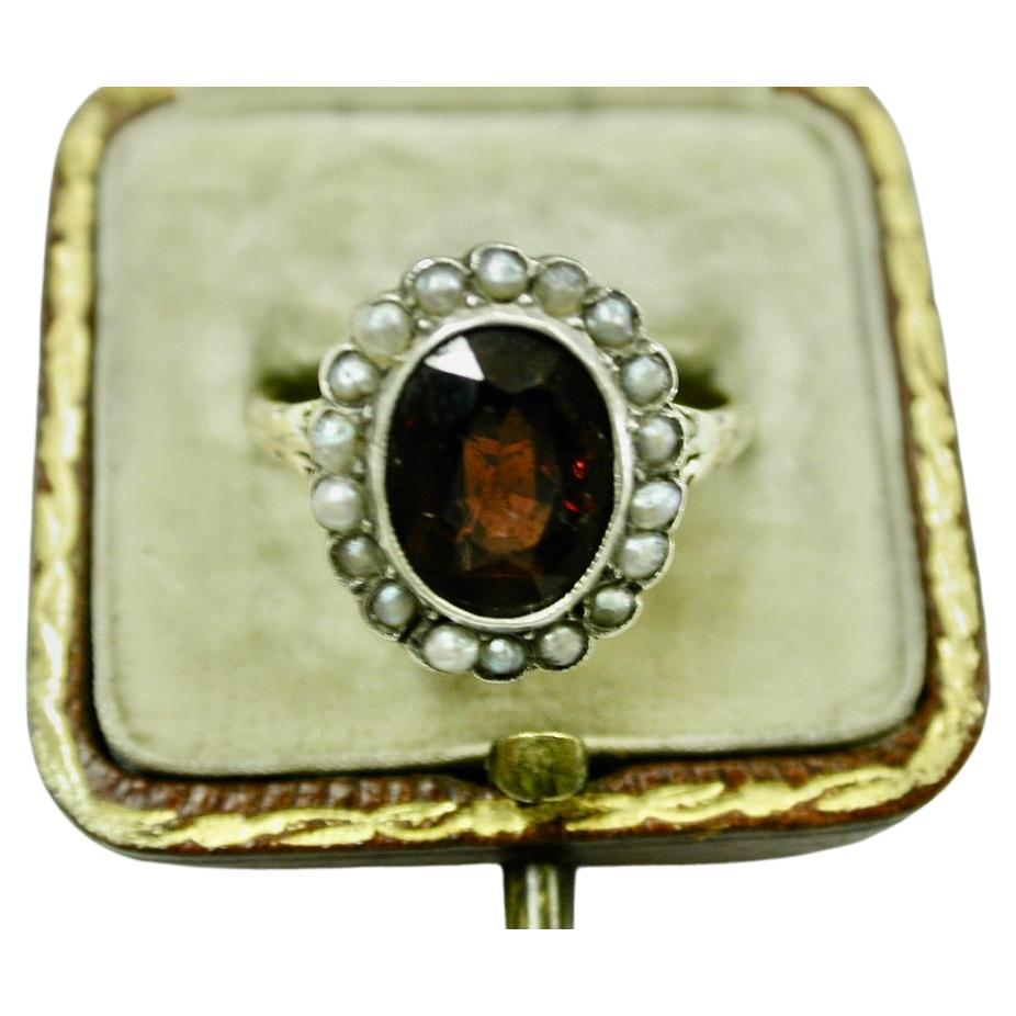 Antique 9ct Gold Ring Set With Pyrope Garnet surrounded with Seed Pearls C 1900
Pretty ring with a 9ct gold shank and silver set top.