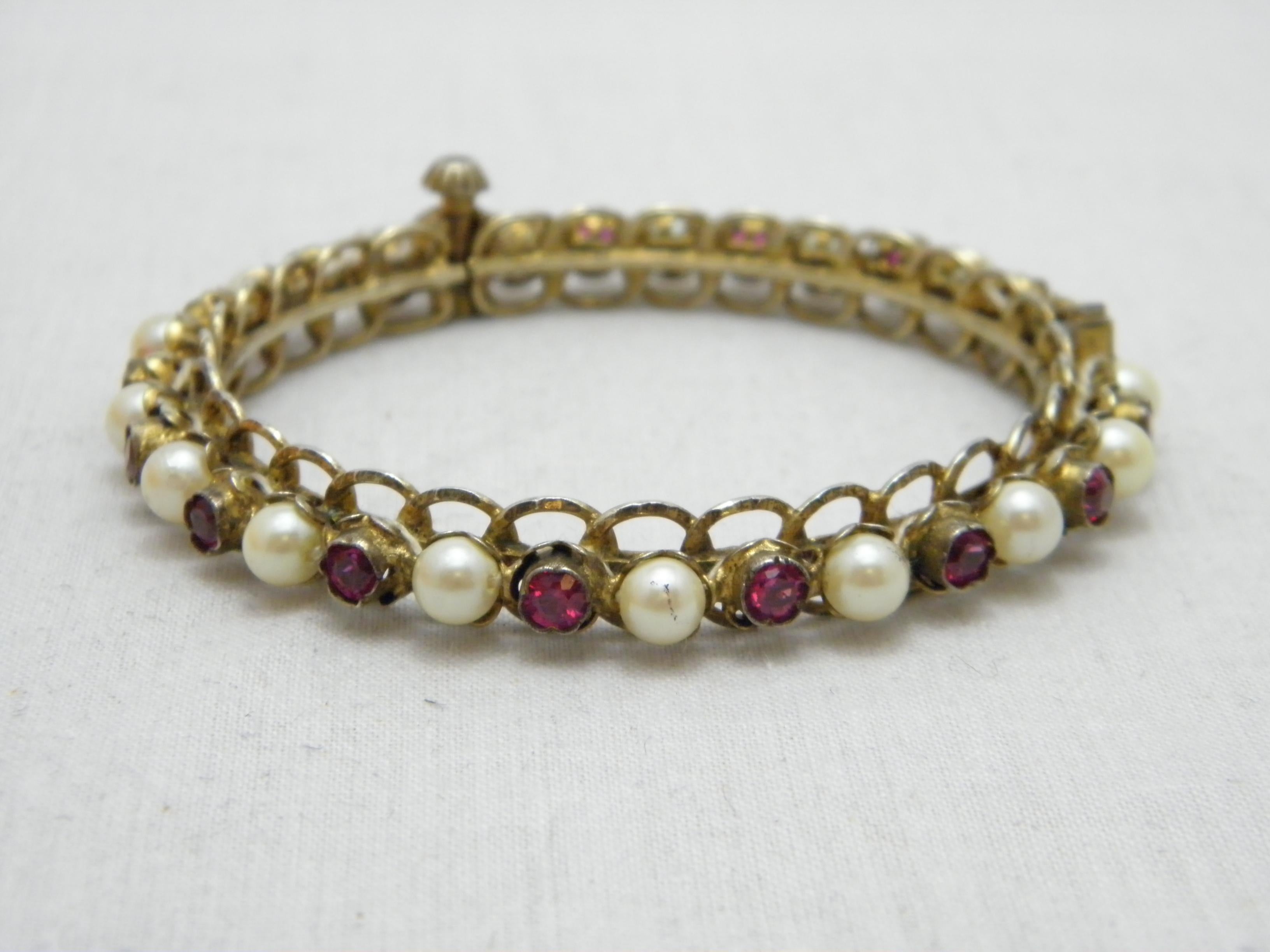 If you have landed on this page then you have an eye for beauty.

On offer is this gorgeous
9CT GOLD ROLLED RUBY AND PEARL PASTE HINGED BANGLE BRACELET

DETAILS
Material: Thick 9ct Rolled Gold (Rosey Yellow)
Style: Hinged Cuff with Ruby and Pearl