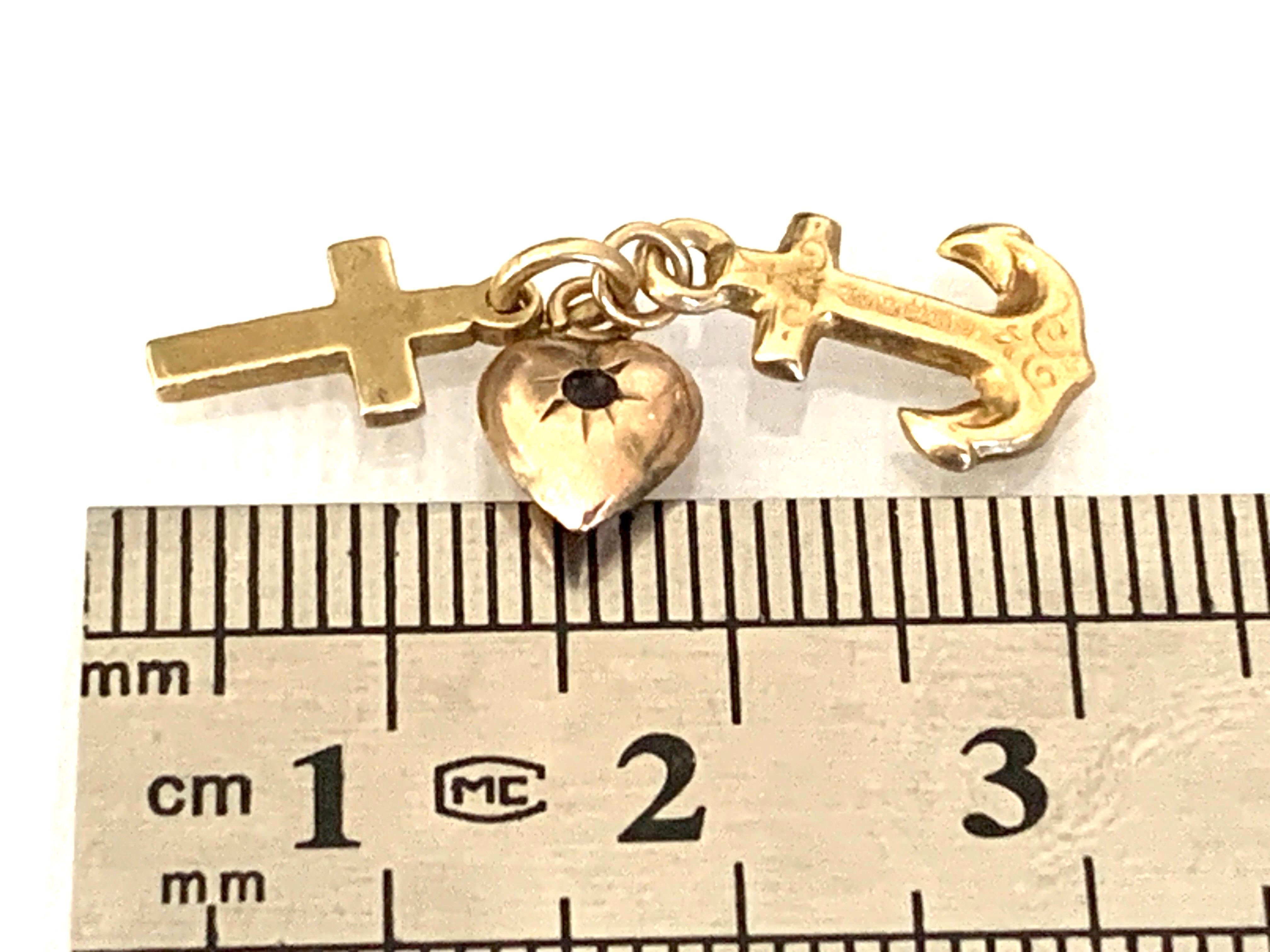 Antique
9ct Gold Trio Charm
Hallmarked 
Cross, Gem set Heart and anchor 
with decorative engraving
all three are hollow 
and placed together on a 9ct stamped closed Jump Ring

Size of each charm approx 1cm high and the heart 7mm high
the heart