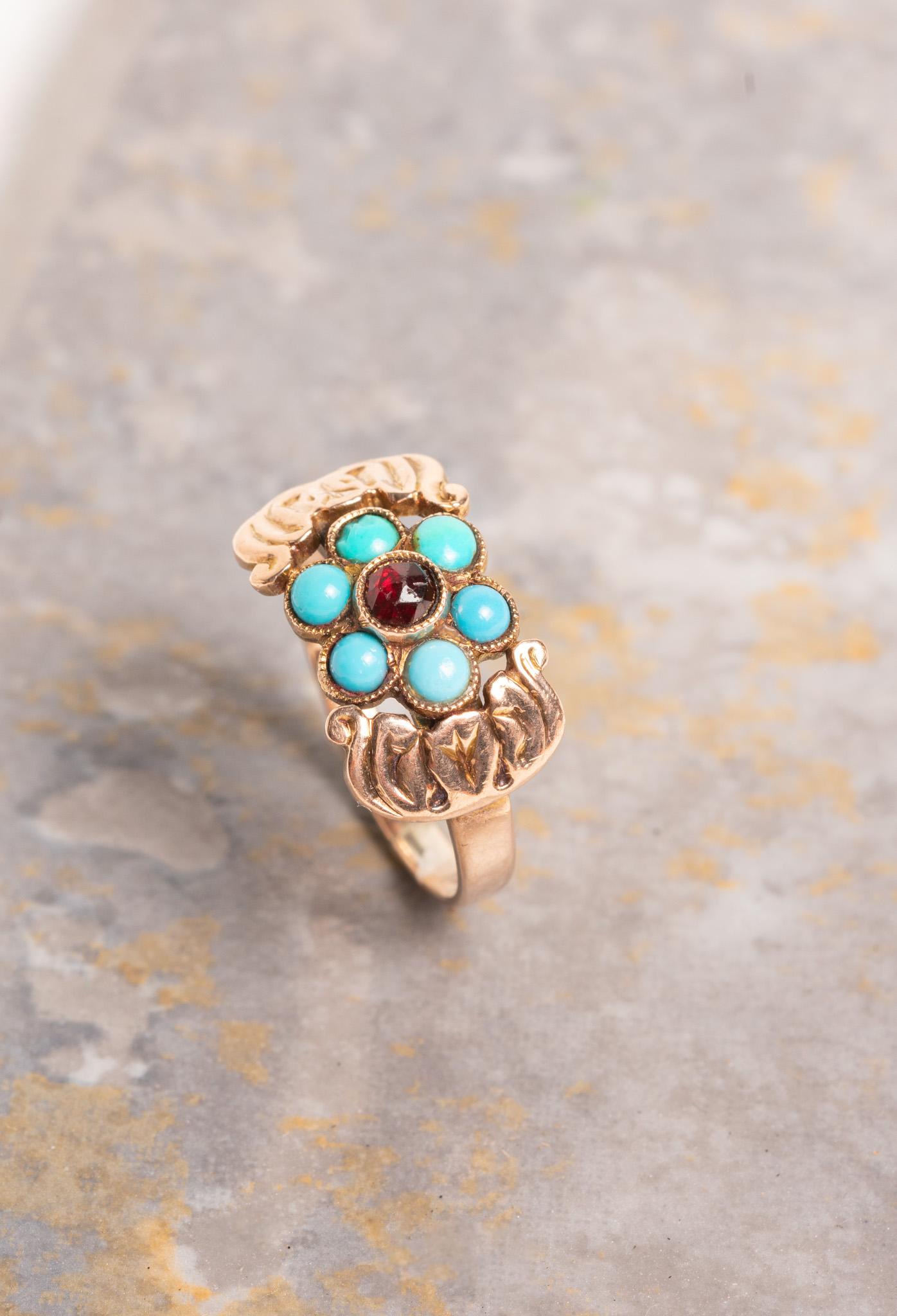 Antico anello vittoriano in oro rosa 9ct con turchese e rubino che presenta un motivo floreale con un bellissimo rubino centrale, poi petali dalla forma splendida con turchese incastonato che rappresenta il fiore del non ricordo. Sei pietre di