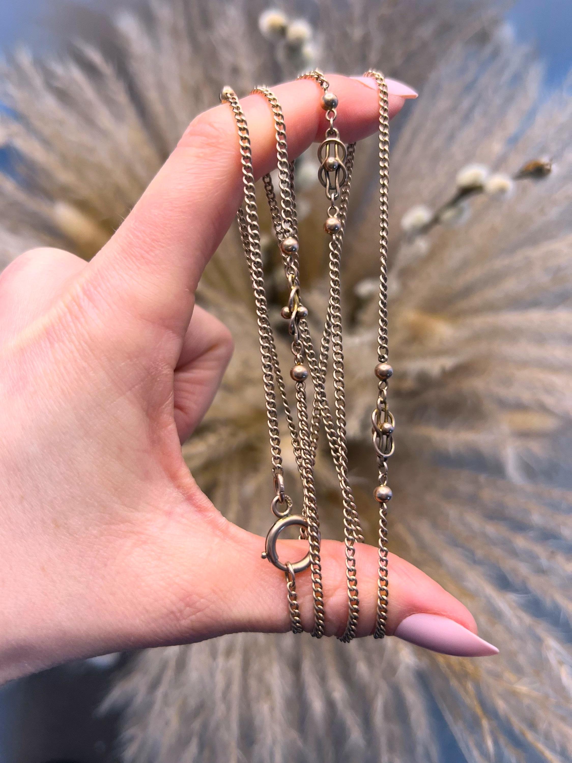 Antique Long Gold Chain 

9ct Rose Gold Stamped 

Circa 1900

Lovely, Edwardian fancy, long chain. Features a flat curb link chain with beautiful fancy knot links & gold balls. The chain fastens with a bolt ring clasp & can be wrapped round the neck