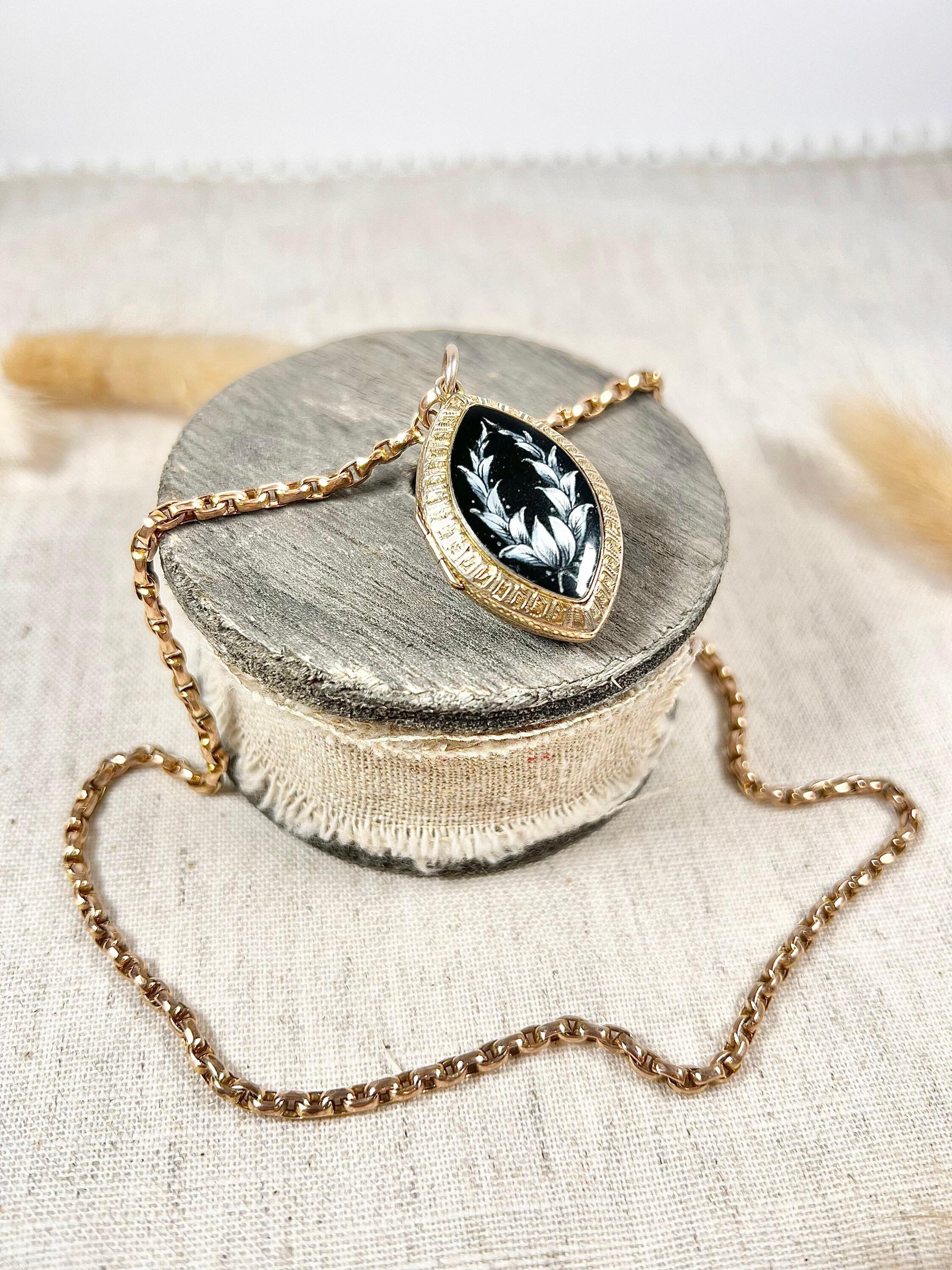 Antique Marquise Locket 

9ct Rose Gold Tested

Circa 1870

Fabulous, Victorian gold locket. A lovely, rare marquise shape. Beautifully decorated with a black enamel surface & white handed painted  flowers. The back is hand carved with gorgeous