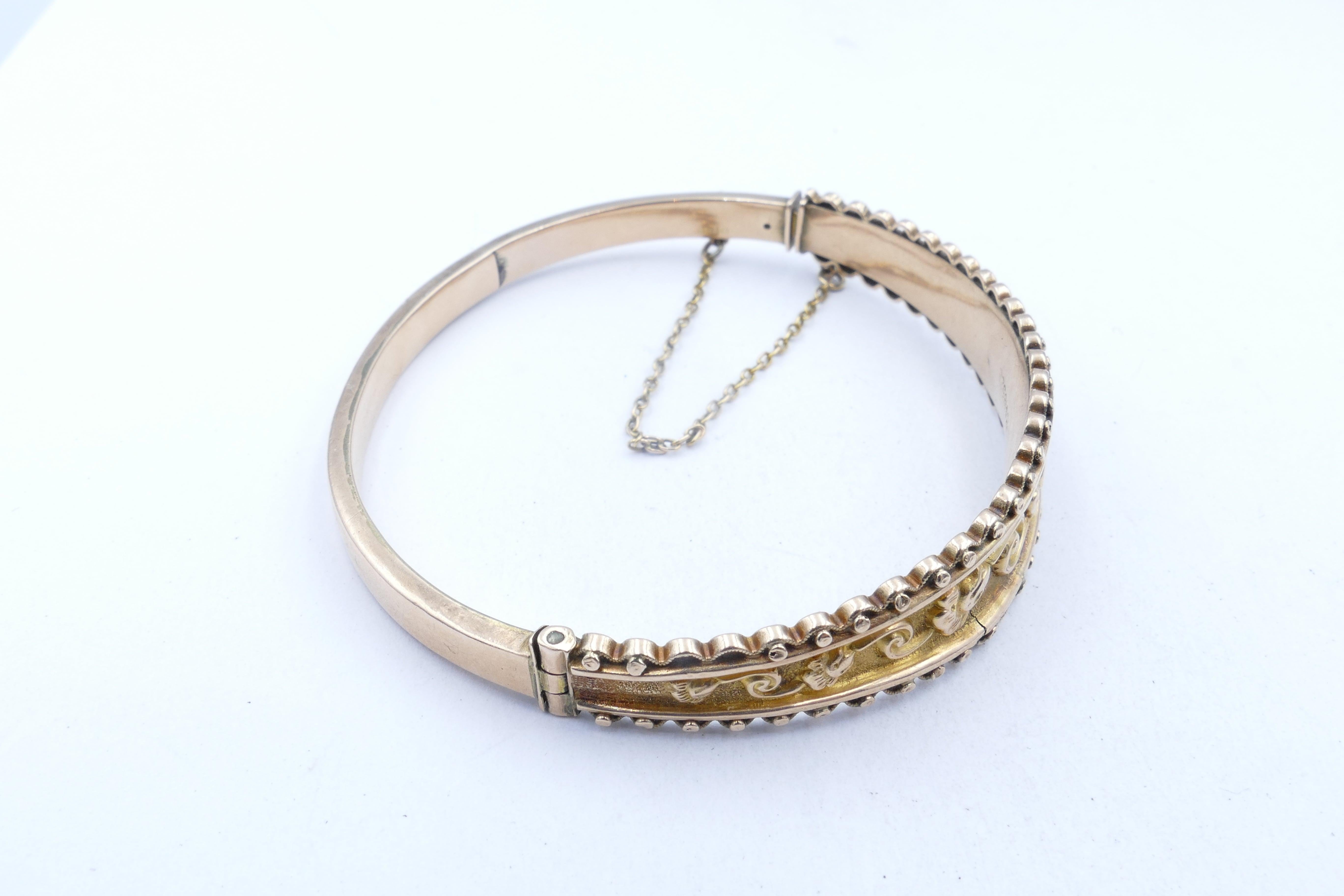 What a very pretty Bangle this is. Edwardian - circa 1905, it is embossed with floral motifs over a textured backdrop with scalloping bead edges at the gallery.
It has a box clasp closure with one oval link safety chain.
It displays English Assay