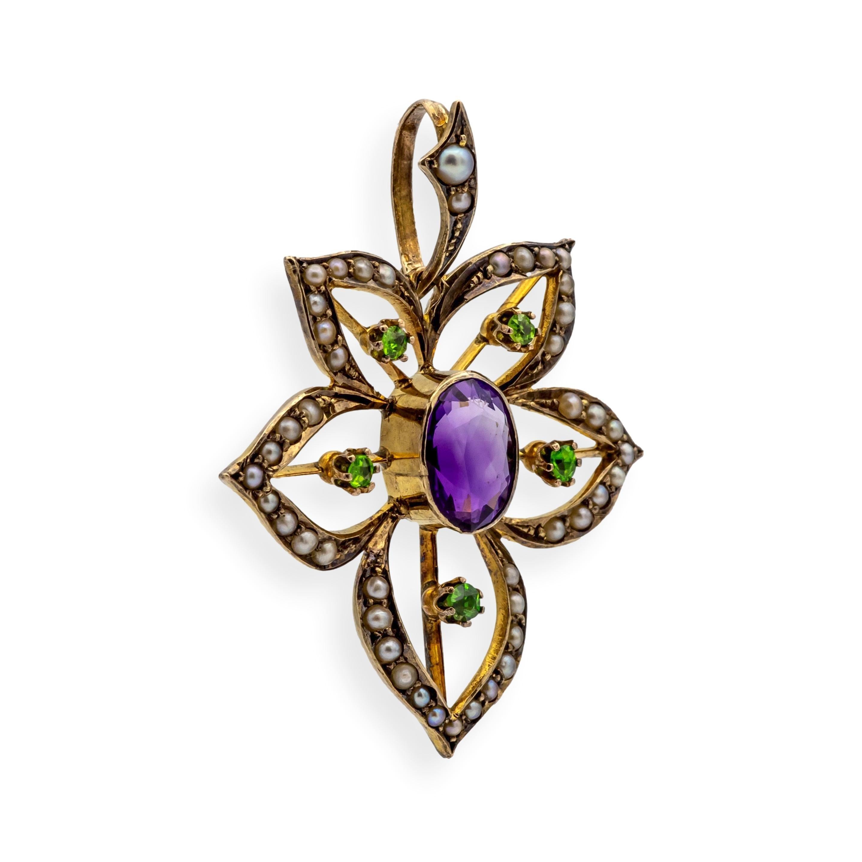 Antique pendant from the Edwardian and Art Nouveau period, featuring a flowing floral motif centered by a richly saturated oval-cut amethyst (approx. 8.4 x 6.4 mm), surrounded by five vivid green demantoid garnets and 45 creamy seed pearls. The