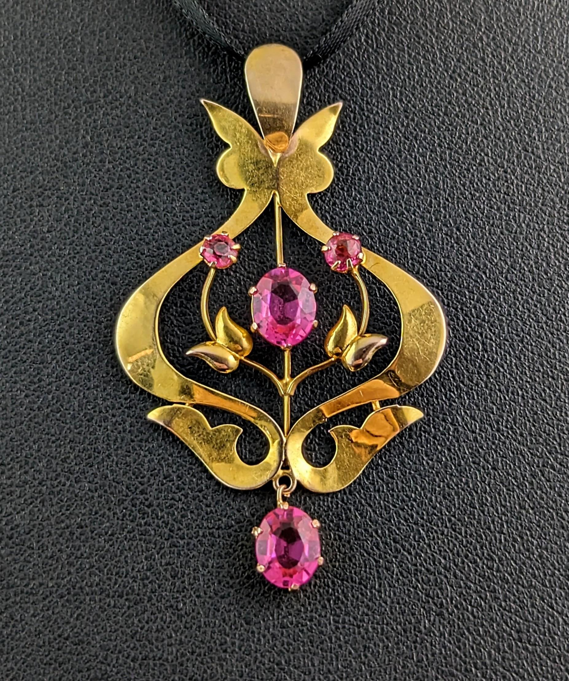 This antique, Art Nouveau era, 9ct gold and pink paste pendant really pops.

It is a lavaliere style pendant, typically popular in the Edwardian / Art Nouveau era, they were usually light and delicate settings but with elaborate designs and skillful