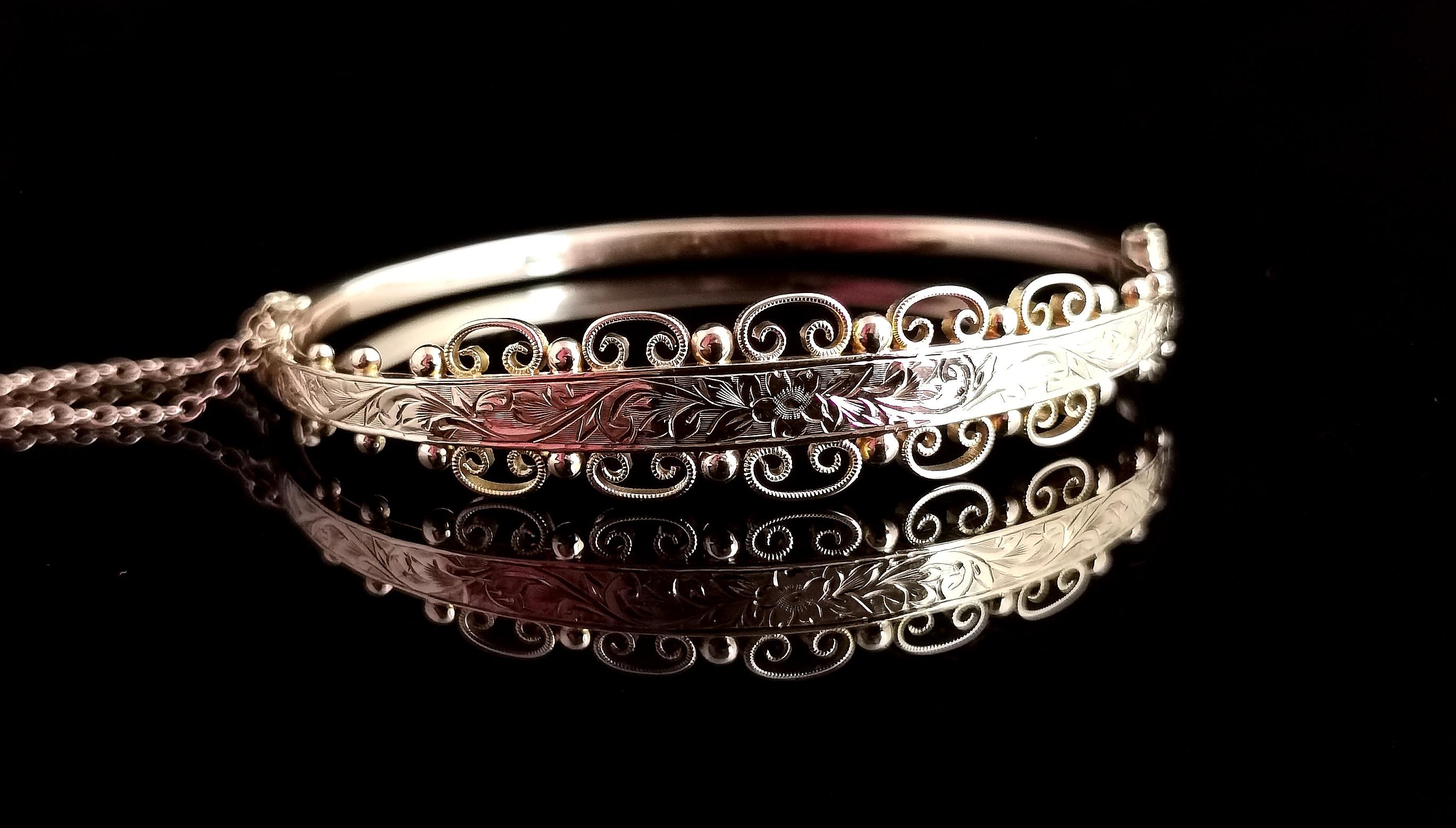 A superb antique Edwardian 9kt gold floral engraved bangle.

A very pretty design with a slim plain polished back.

The front is wider with an elaborate floral engraving bordered by gold beading and scroll work.

A truly beautiful and intricate