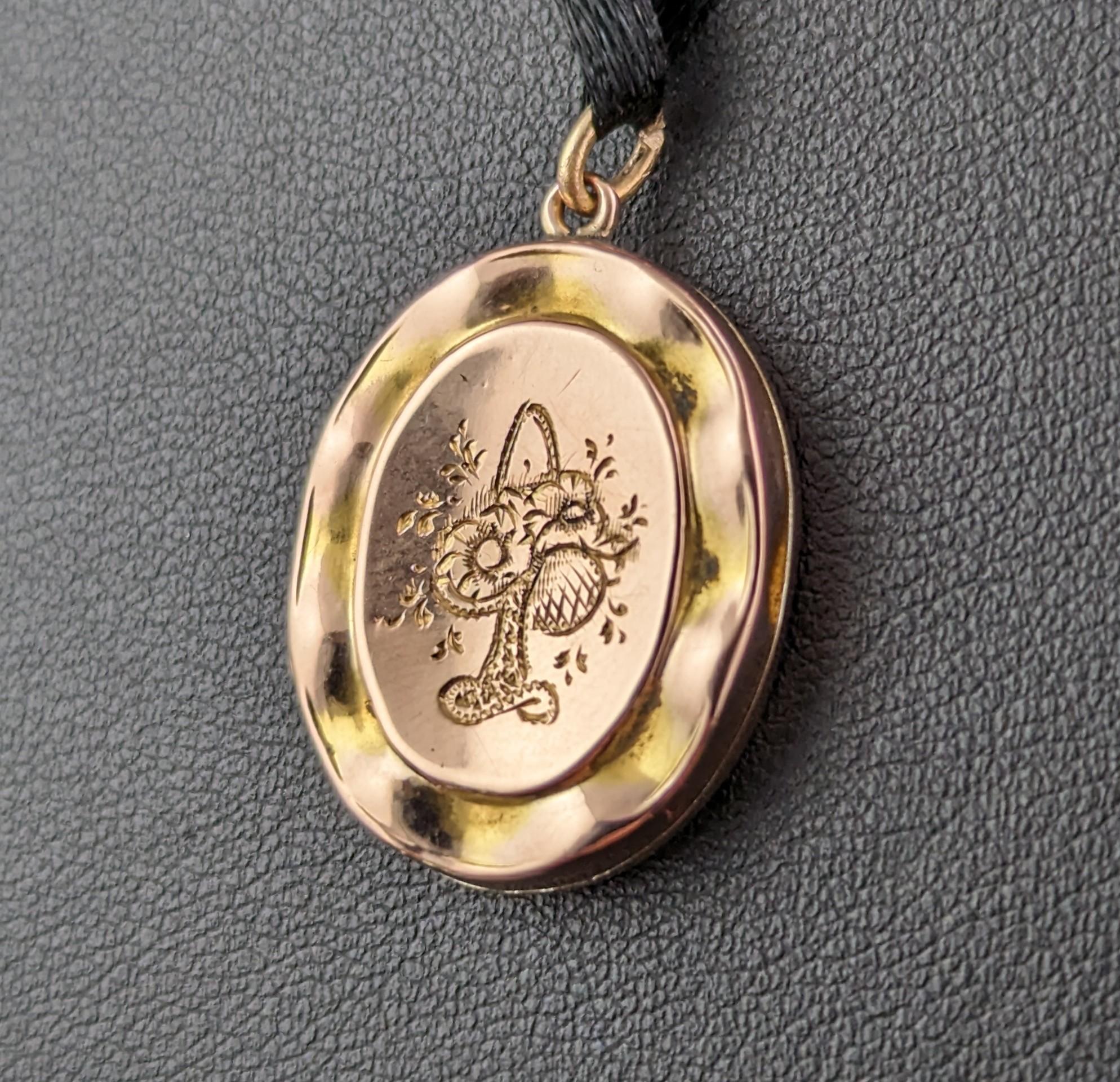 A delightful little antique 9ct gold front and back locket pendant.

Edwardian era it has elaborately engraved designs front and back, one side engraved with a lovely basket of flowers and the other with a bird and foliate.

It has the most