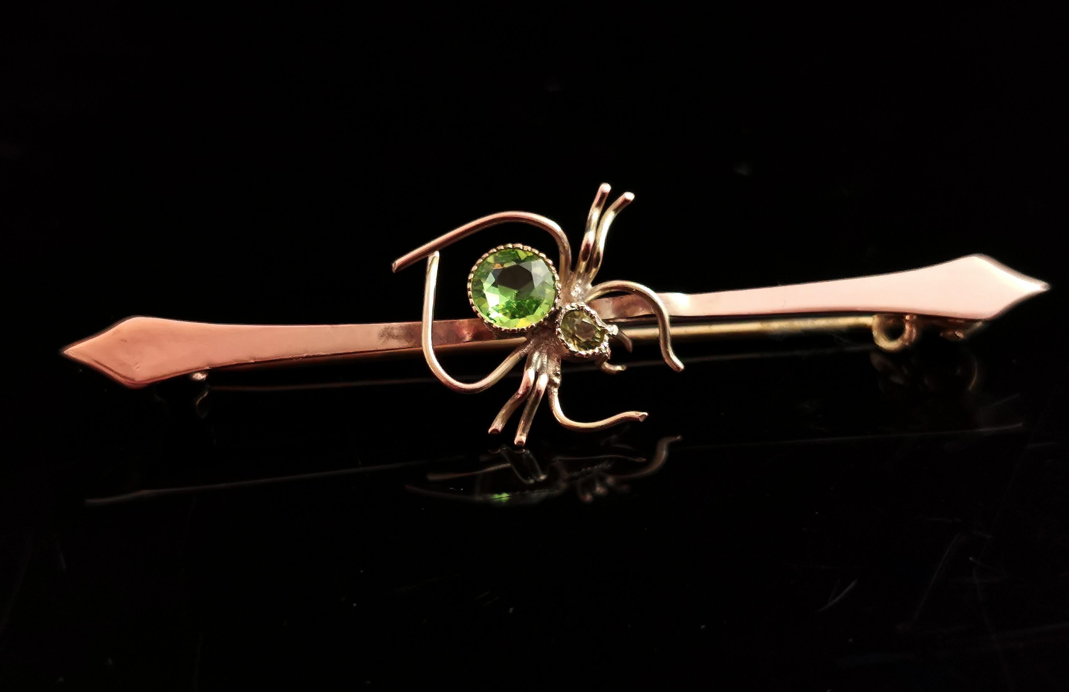 A fantastic antique, Edwardian 9kt gold spider brooch.

The body is made up of a vibrant green round faceted paste stone and the head is a light green peridot stone.

All set in 9kt yellow gold and mounted onto a 9kt gold bar brooch the bar has kite