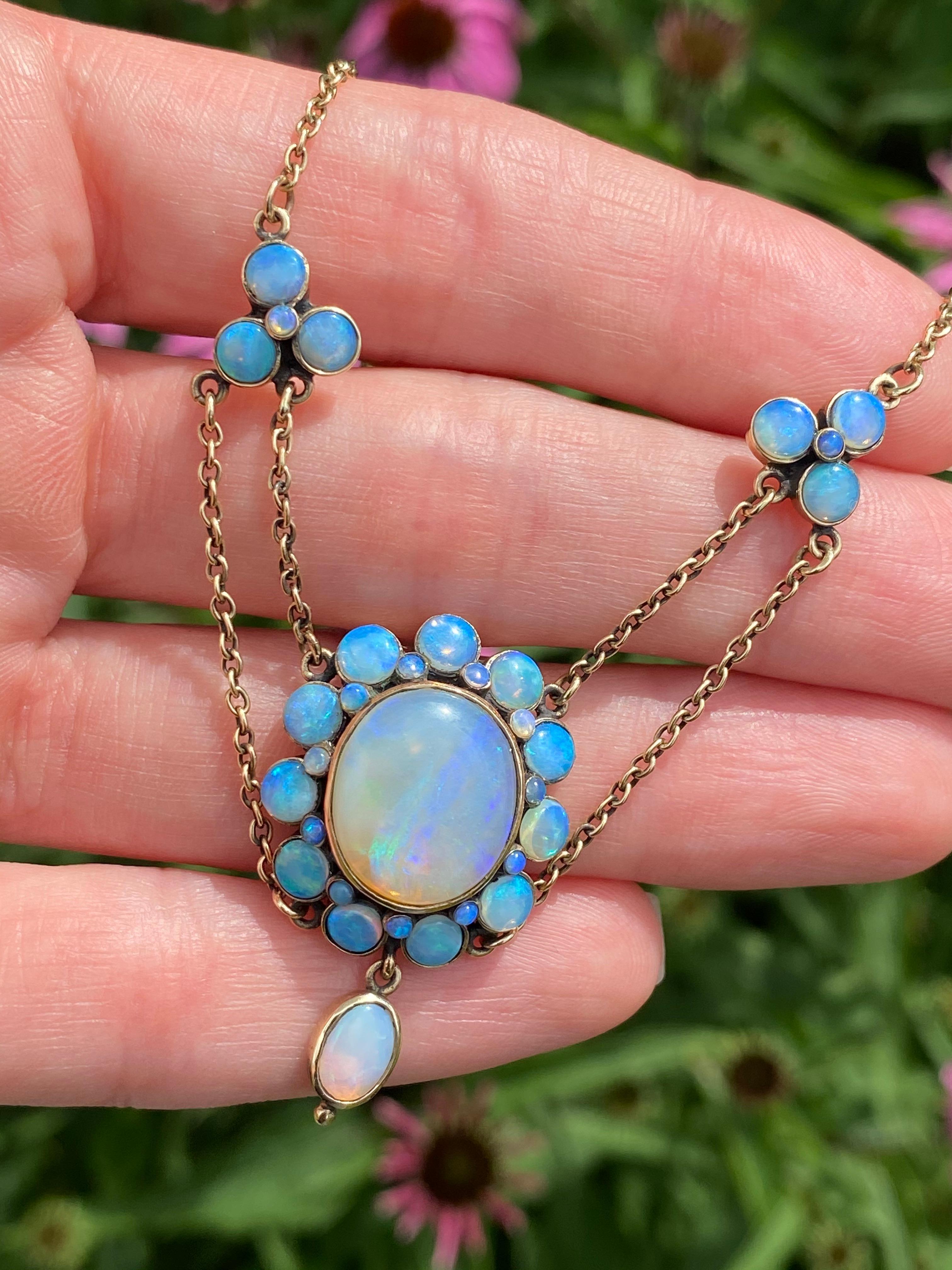 Opals are proof of mother natures magic and this bouquet of cheerful opal flowers contains kaleidoscope of ocean blues and electric purples blend perfectly with flashes of lime green and bubblegum pink. This early 20th century necklace is backed in