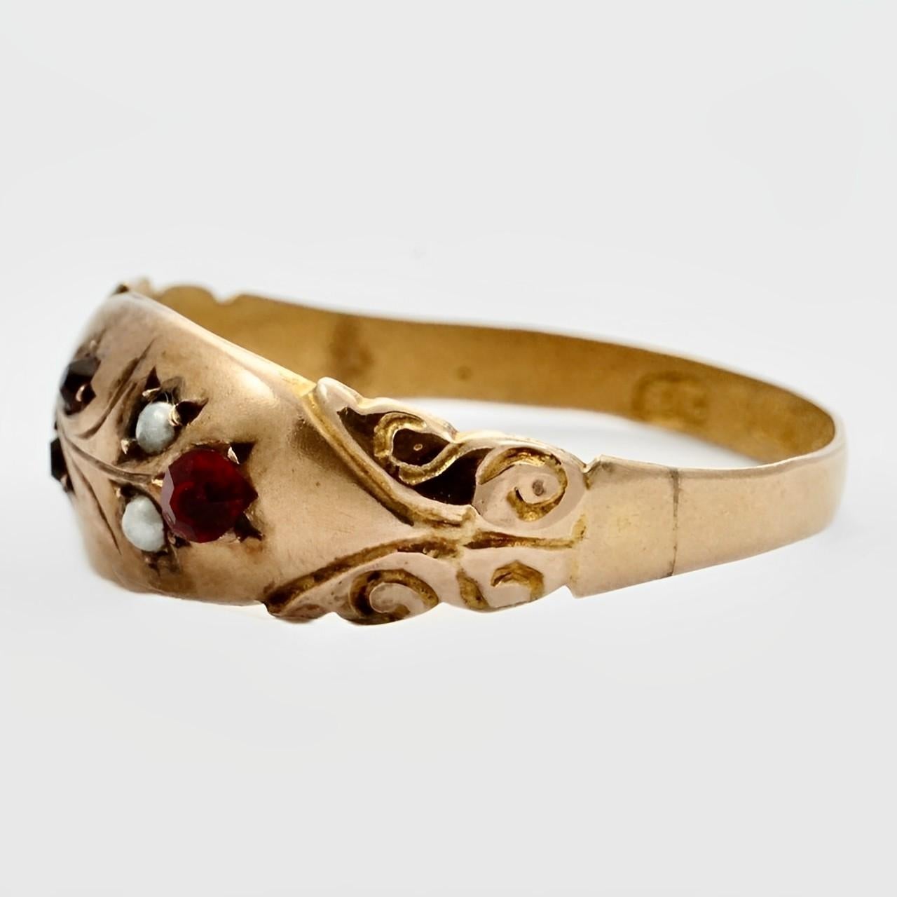 Beautiful antique 9K rose gold hand engraved flower ring, with red stones and faux seed pearls. The larger red stone is a replacement paste stone, the two small red stones are probably rubies or garnets.

The ring has English hallmarks for 9K gold,