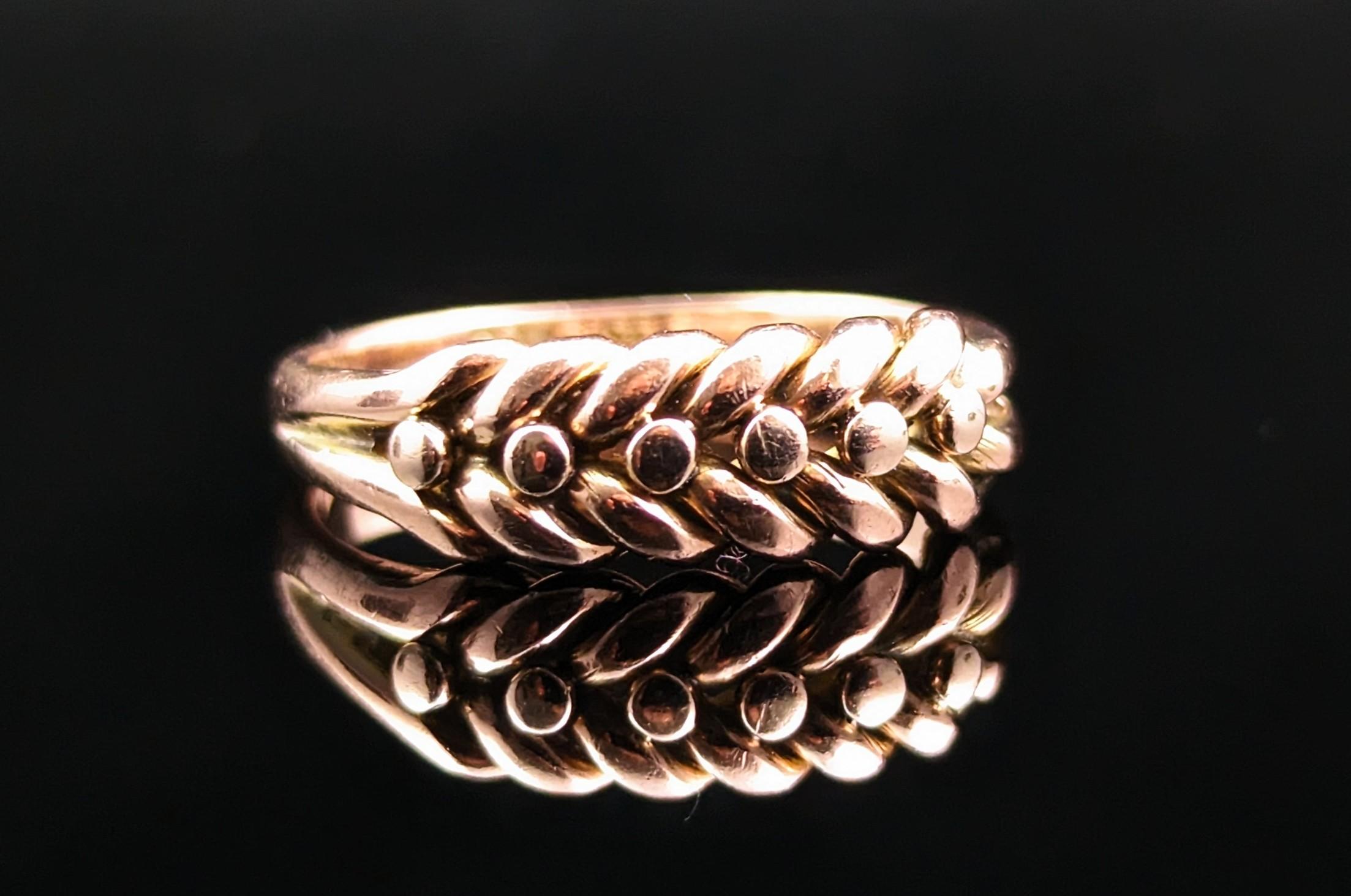 The keeper ring is a classic and highly sought after ring style, this antique Victorian era keeper ring is one of our favourites.

The face is made up from a scrolling knot with beading and this leads to the bifurcated shoulders and smooth chunky