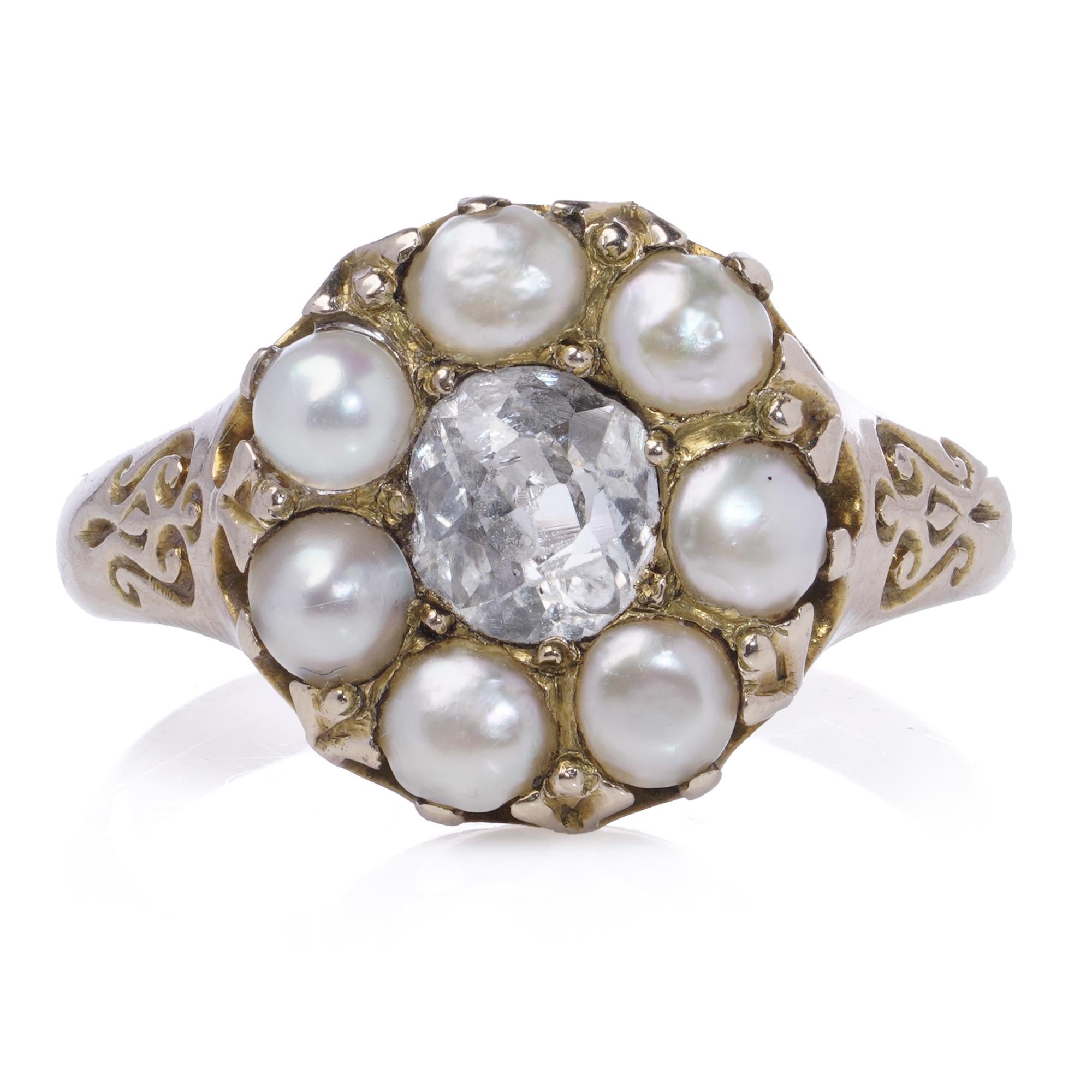 Antique 9K yellow gold cluster ring, featuring a central old mine-cut diamond surrounded by a halo of seven natural saltwater pearls.
Ornate openwork detailing adorns the shoulders.

Specifications:
Material: 9K Yellow Gold
Gemstones:
Diamond: