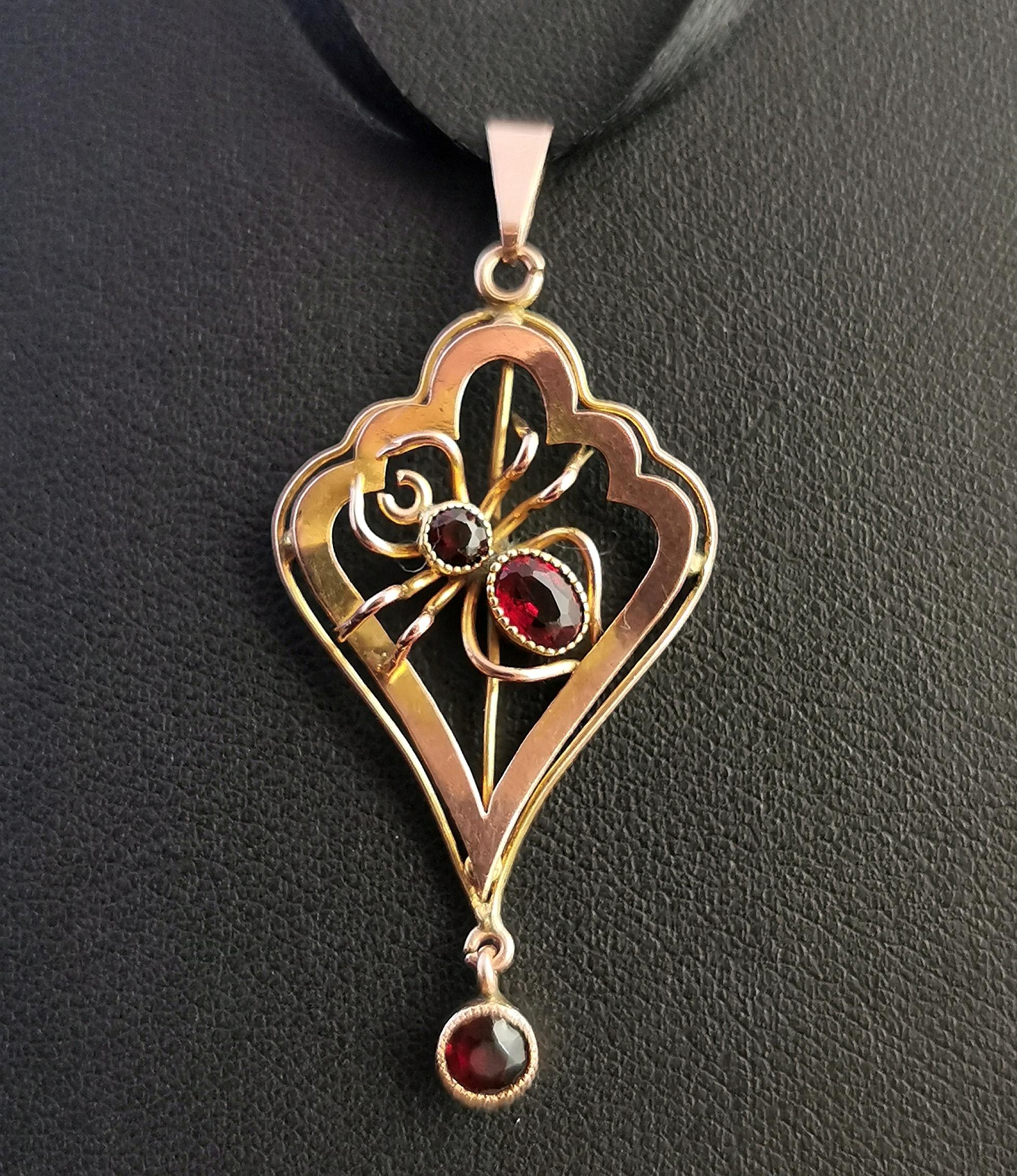 A superb antique Art Nouveau era 9 karat gold pendant and paste spider pendant.

To the centre of the pendant there is a little gold spider set with deep red paste stones.

Lavalier style with scrolling gold wirework accents and a little articulated