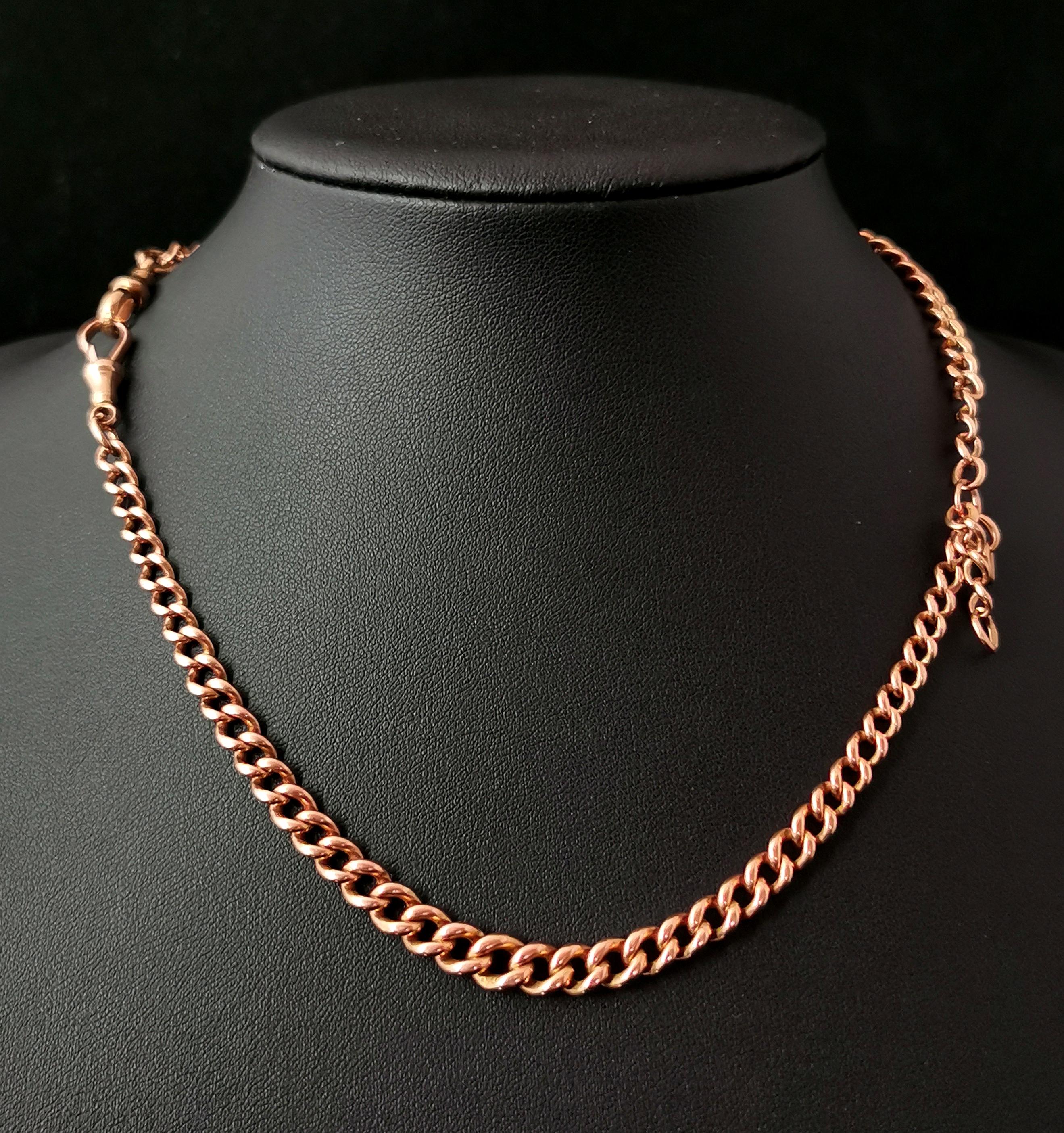 A handsome antique Edwardian era 9kt Rose gold Albert chain.

It is a curb link chain in 9kt Rose gold, each link individually stamped for 9kt gold, 9.375.

A double Albert graduating in link width adjoined in the centre with a large gold jump ring