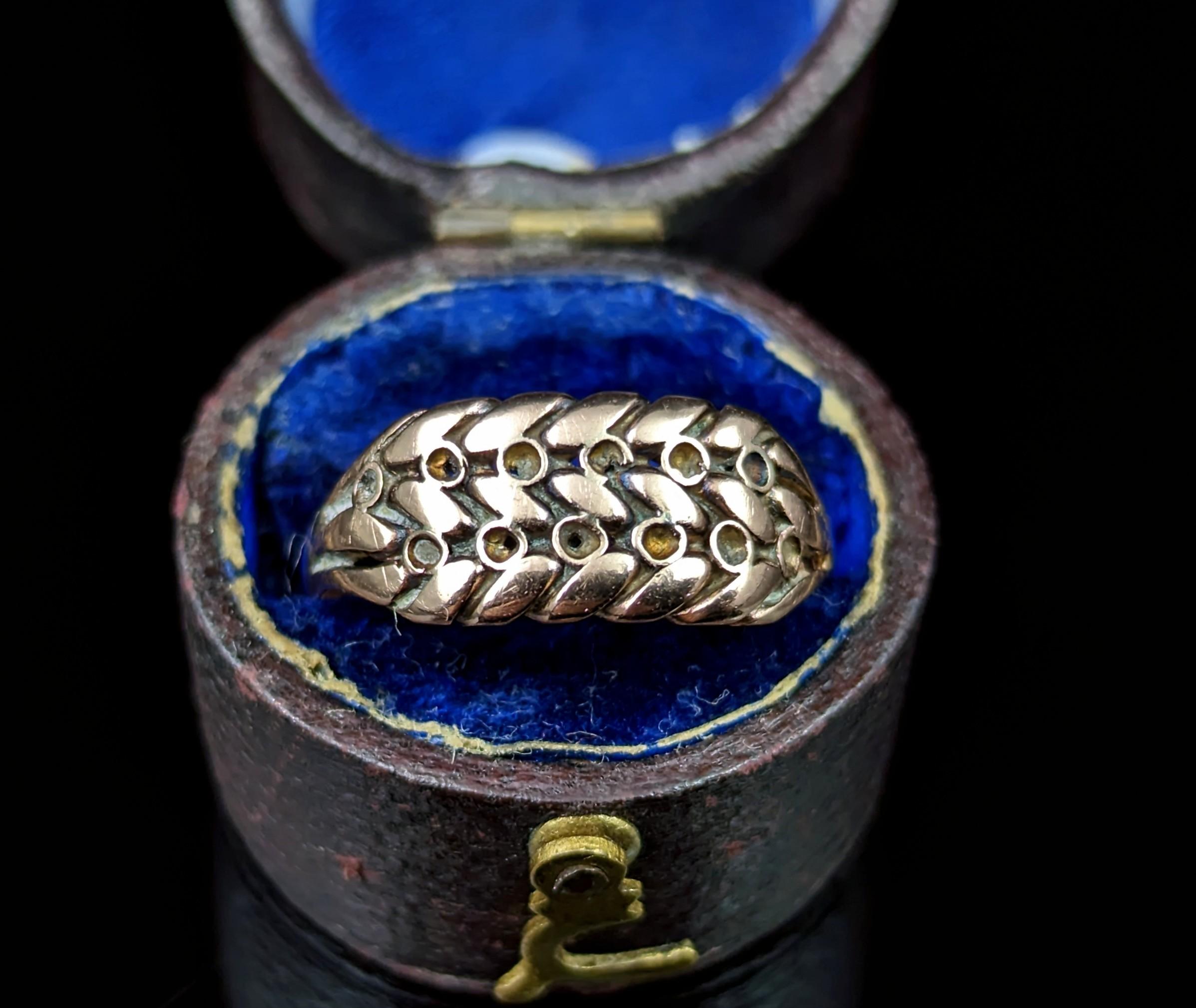 The keeper ring is a classic and highly sought after ring style, like this antique Edwardian era 9kt rose gold keeper ring.

The face is made up from a scrolling knot with beading and this leads to the bifurcated shoulders and smooth gold band.

The